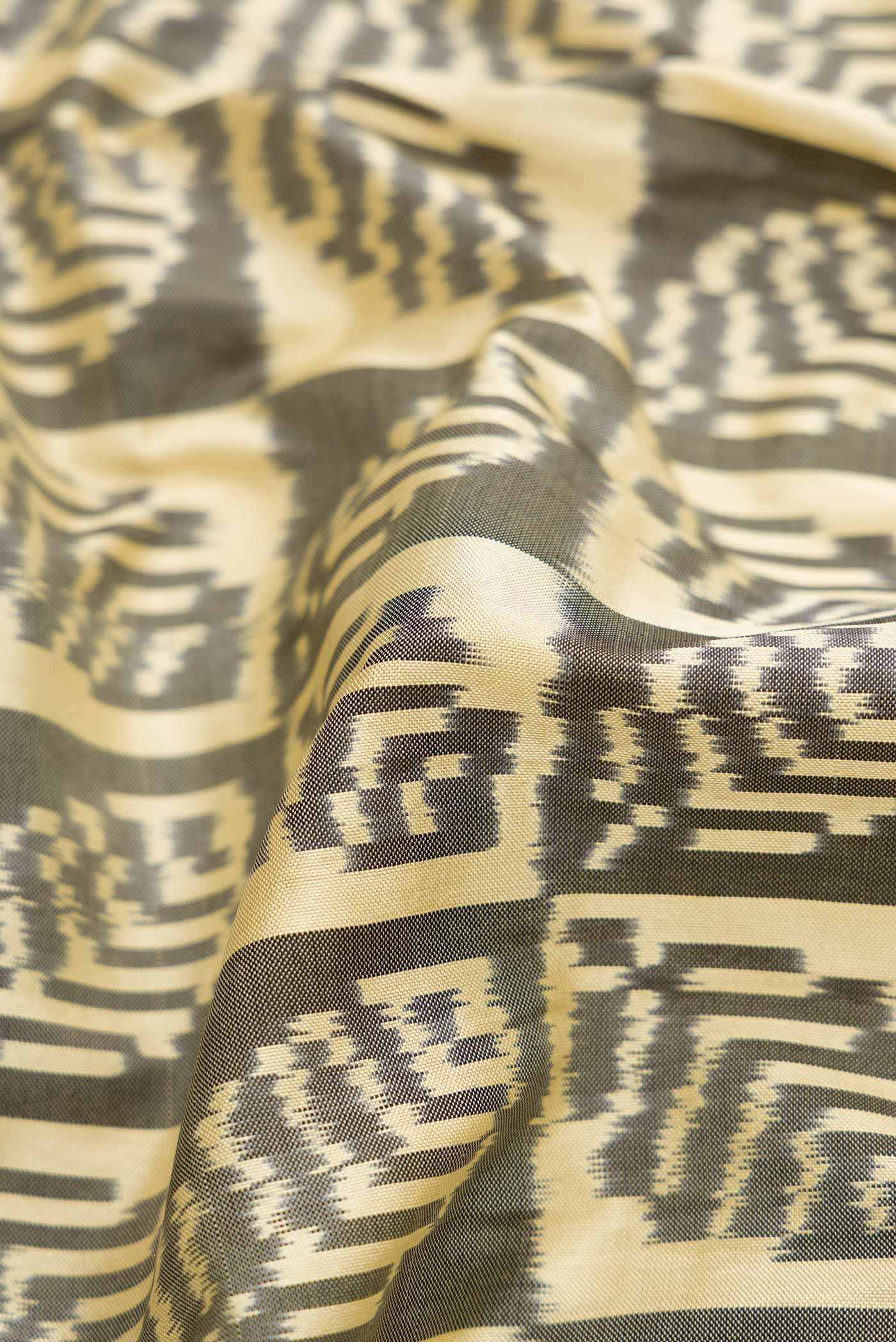 Close up of Sandal Pochampally Silk Saree with Pure Ikat on the body and Zari Border displaying folds