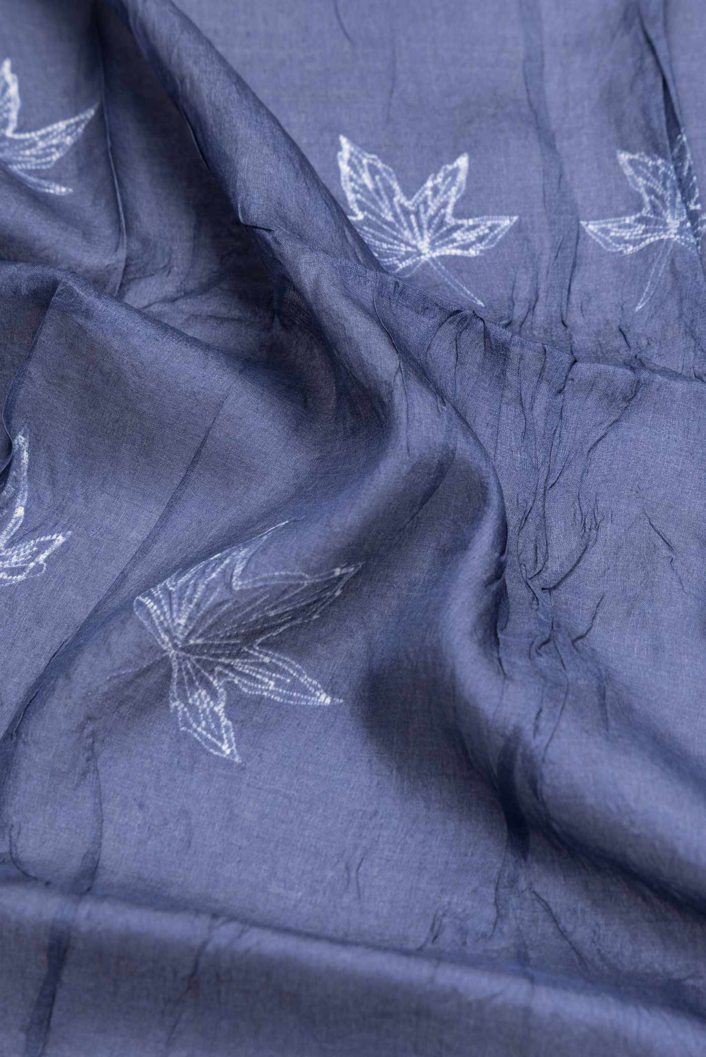 Close up of Navy Blue Dual Tone Tussar Saree with Printed design on the body and Zari Border.  displaying folds