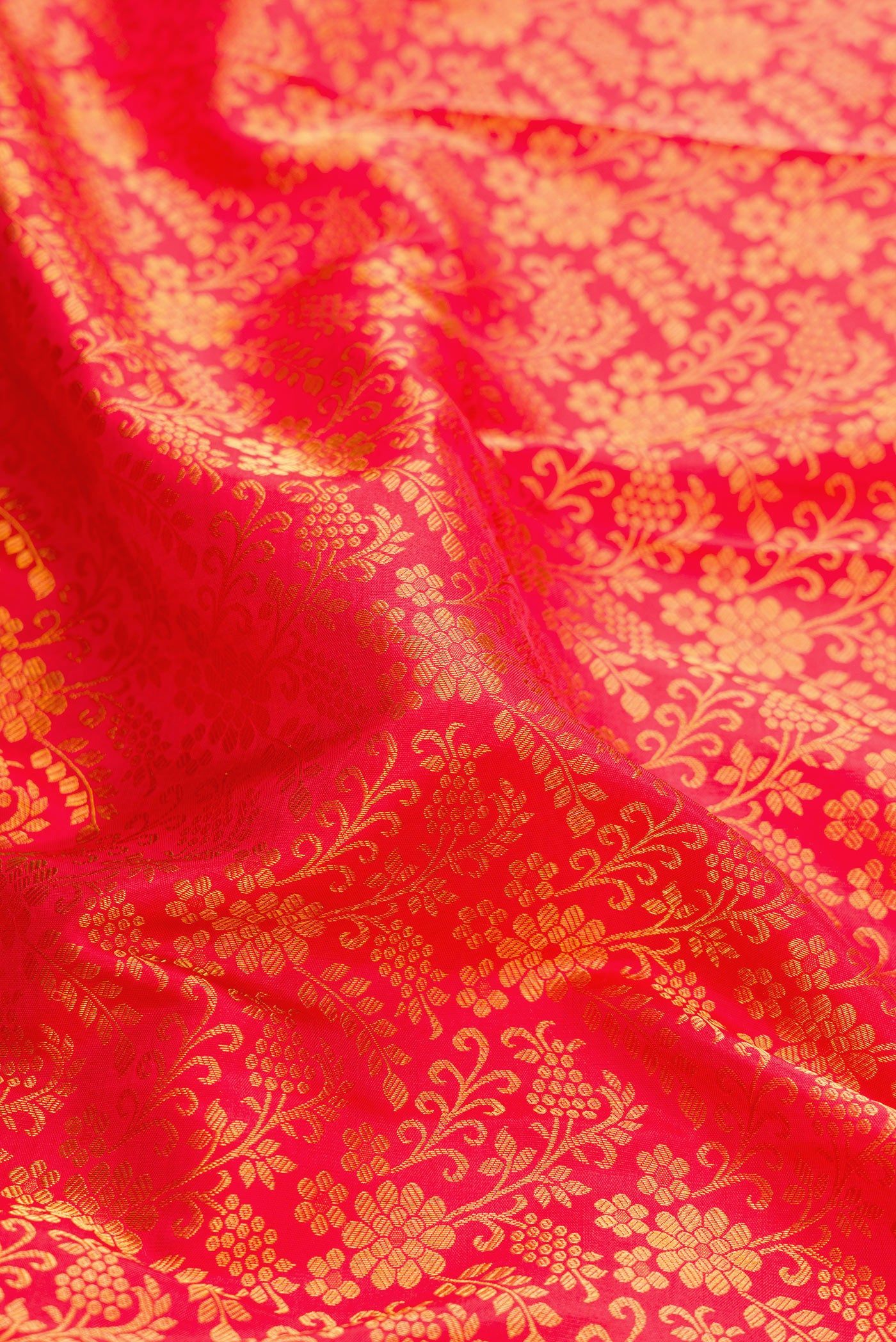 Close up of Red Dual Tone Kanjivaram Silk Saree with Zari Brocade on the body and Zari Border.  displaying folds