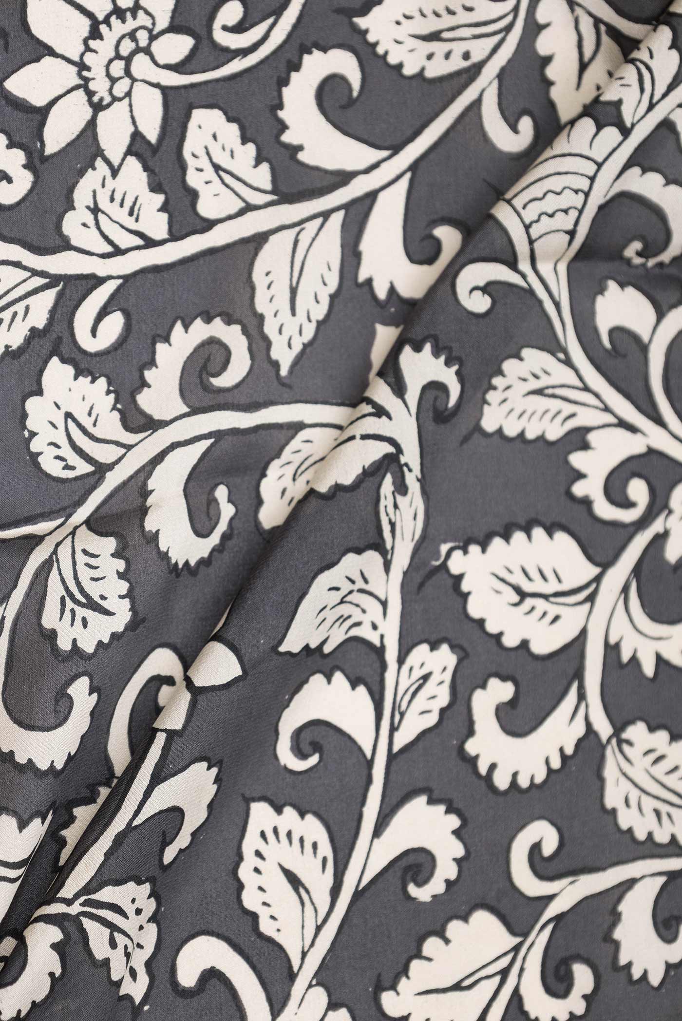Close up of Grey Dual Tone Mysore Crepe Saree with Printed design on the body and Zari Border displaying folds