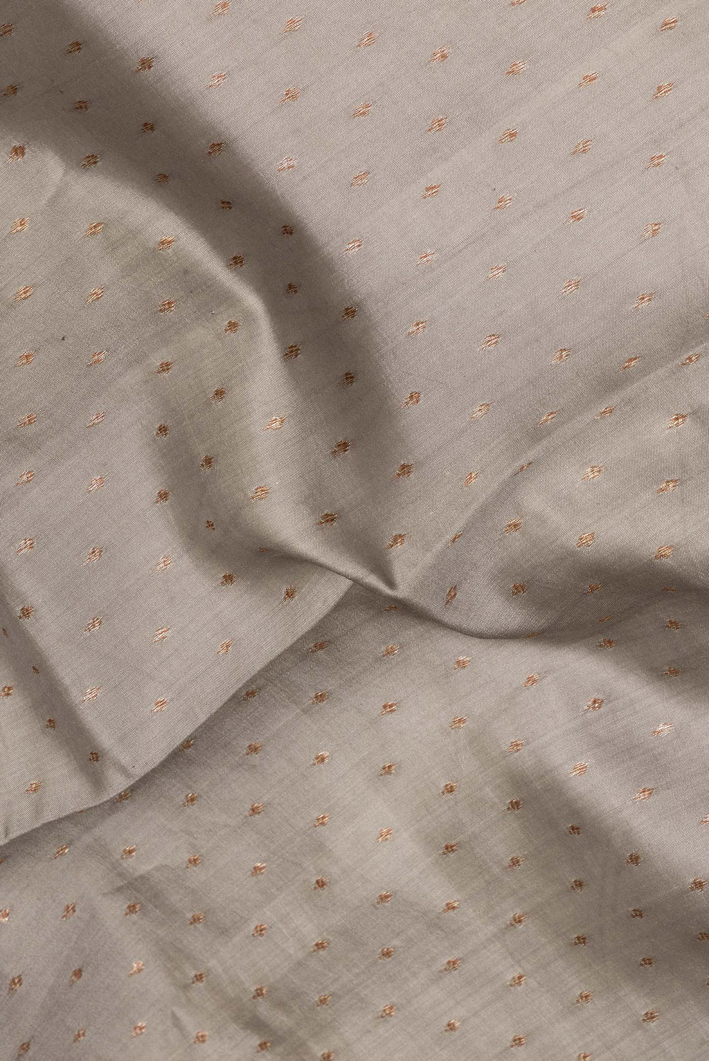 Close up of Pure Silk Grey Tussar Saree with Zari Butta on the body and Zari Border.  displaying folds