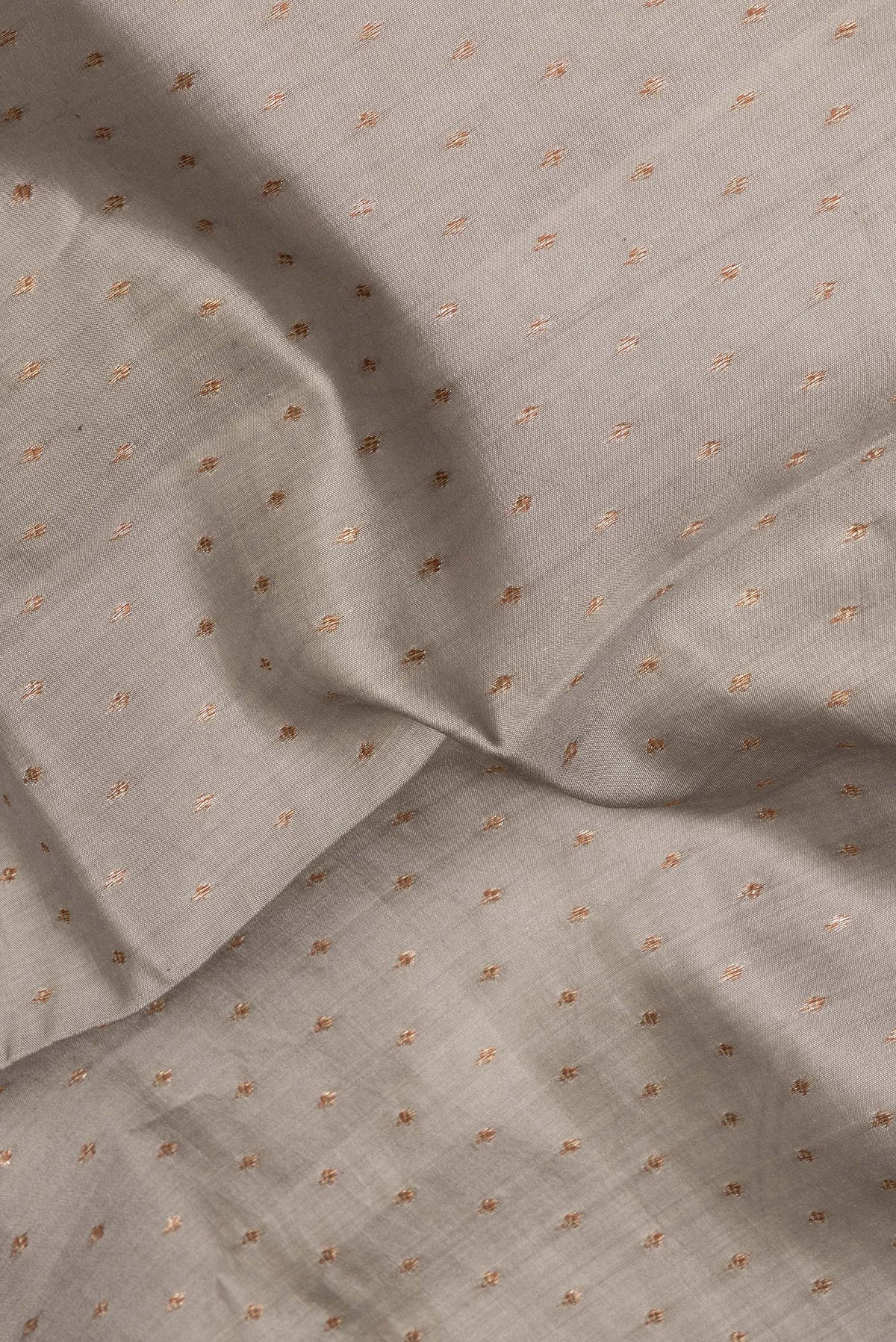 Close up of Pure Silk Grey Tussar Saree with Zari Butta on the body and Zari Border.  displaying folds