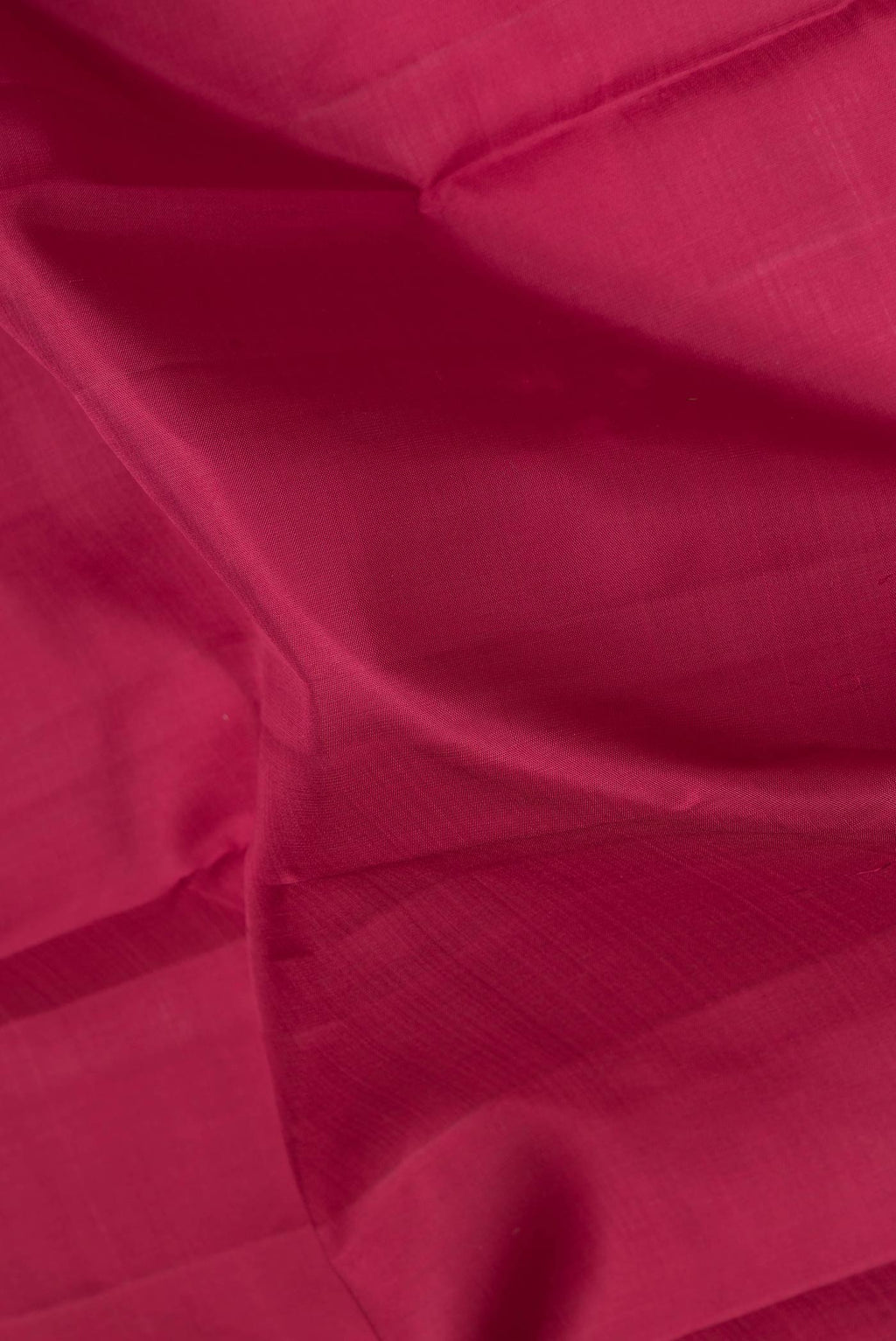 Close up of Maroon Dual Tone Kanchipuram Saree with Plain Body and Zari Border.  displaying folds