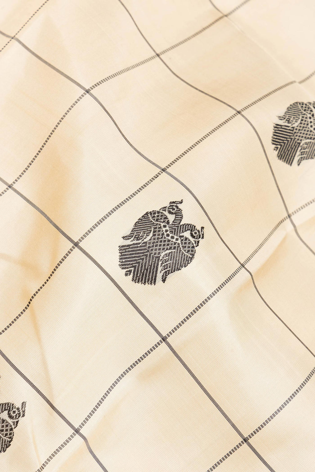 Close up of Pure Silk Beige Dual Tone Kanchipuram Saree with Checked design on the body and Thread Border.  displaying folds