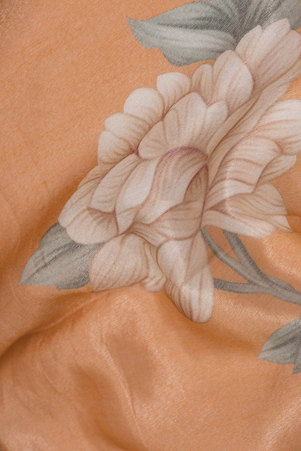 Close up of Orange Dual Tone Organza Silk Saree with Printed design on the body and Zari Border.  displaying folds
