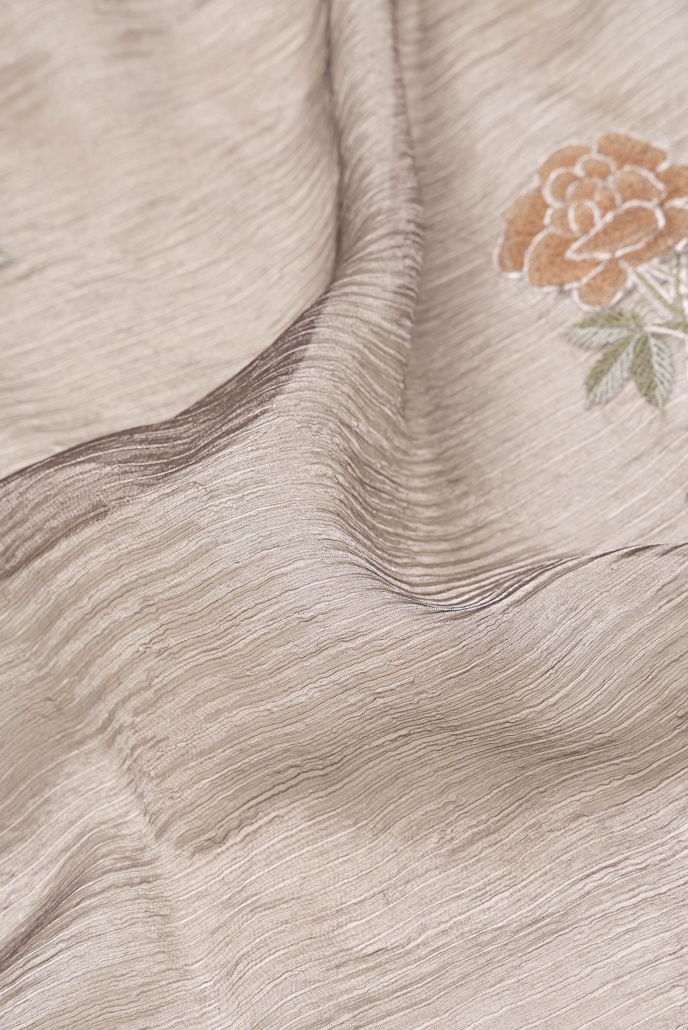 Close up of Brown Dual Tone Organza Silk Saree with Embroidery on the body and Zari Border.  displaying folds