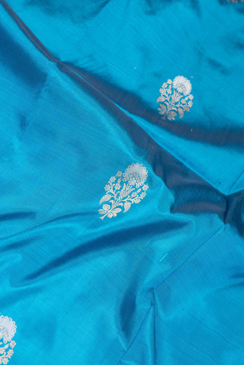 Close up of Peacock Blue Dual Tone Banarasi Silk Saree with Zari Butta on the body and Zari Border.  displaying folds