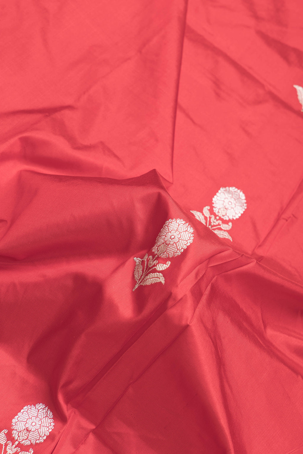 Close up of Red Dual Tone Banarasi Silk Saree with Zari Butta on the body and Thread Border.  displaying folds