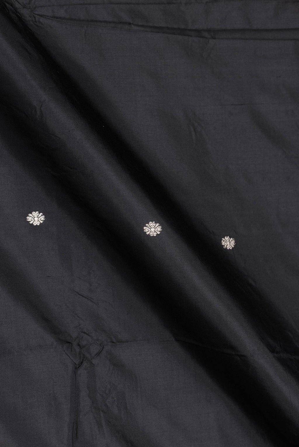 Close up of Black Dual Tone Banarasi Silk Saree with Zari Butta on the body and Zari Border displaying folds