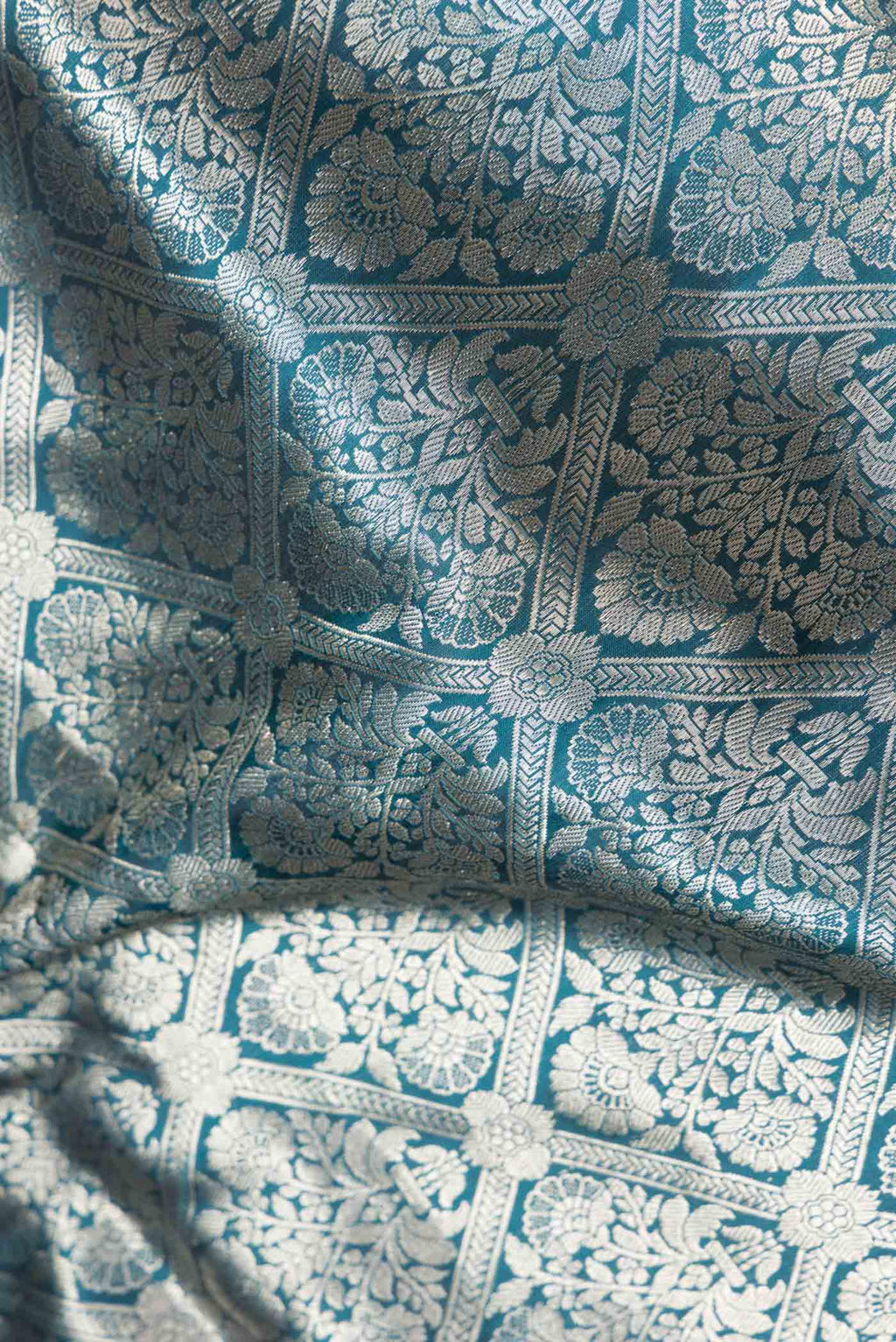 Close up of Peacock Blue Dual Tone Banarasi Silk Saree with Zari Brocade on the body and Zari Border.  displaying folds