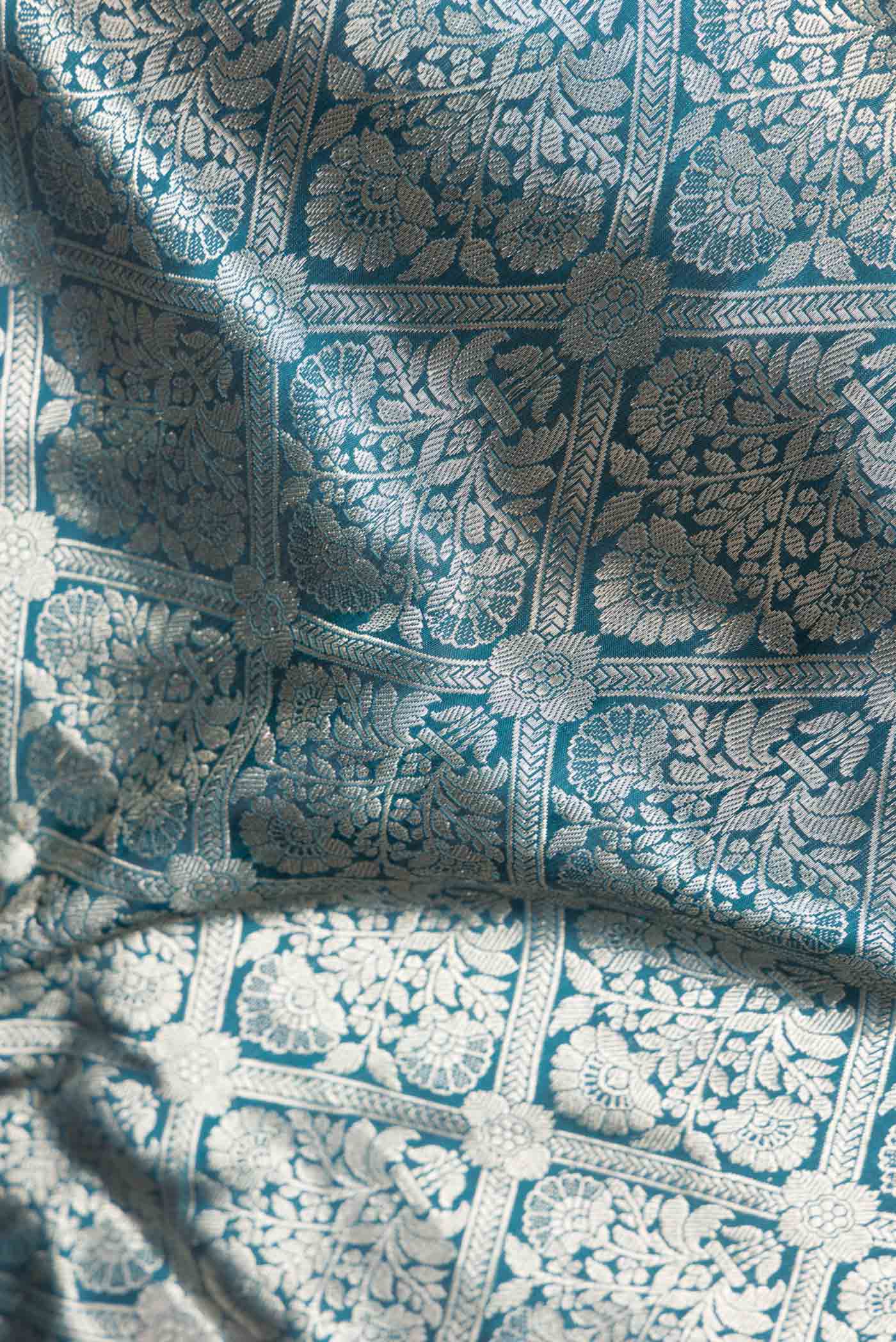 Close up of Peacock Blue Dual Tone Banarasi Silk Saree with Zari Brocade on the body and Zari Border.  displaying folds