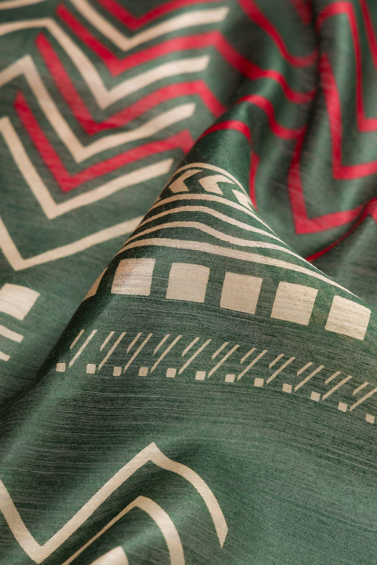 Close up of Green Dual Tone Tussar Silk Saree with Printed design on the body and Zari Border.  displaying folds
