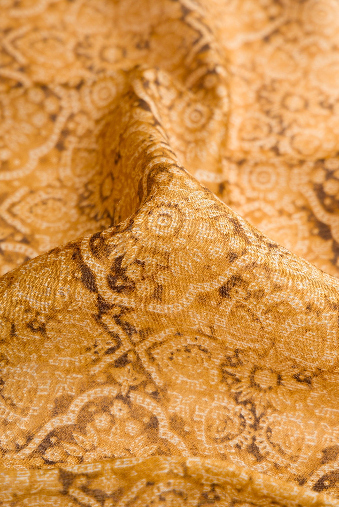 Close up of Mustard Dual Tone Tussar Silk Saree with Printed design on the body and Zari Border.  displaying folds