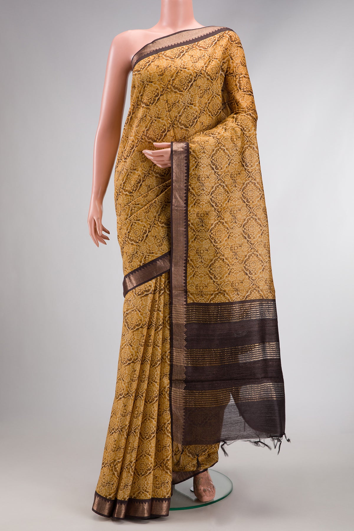 Mustard Dual Tone Tussar Silk Saree with Printed design on the body and Zari Border.  displayed on a mannequin