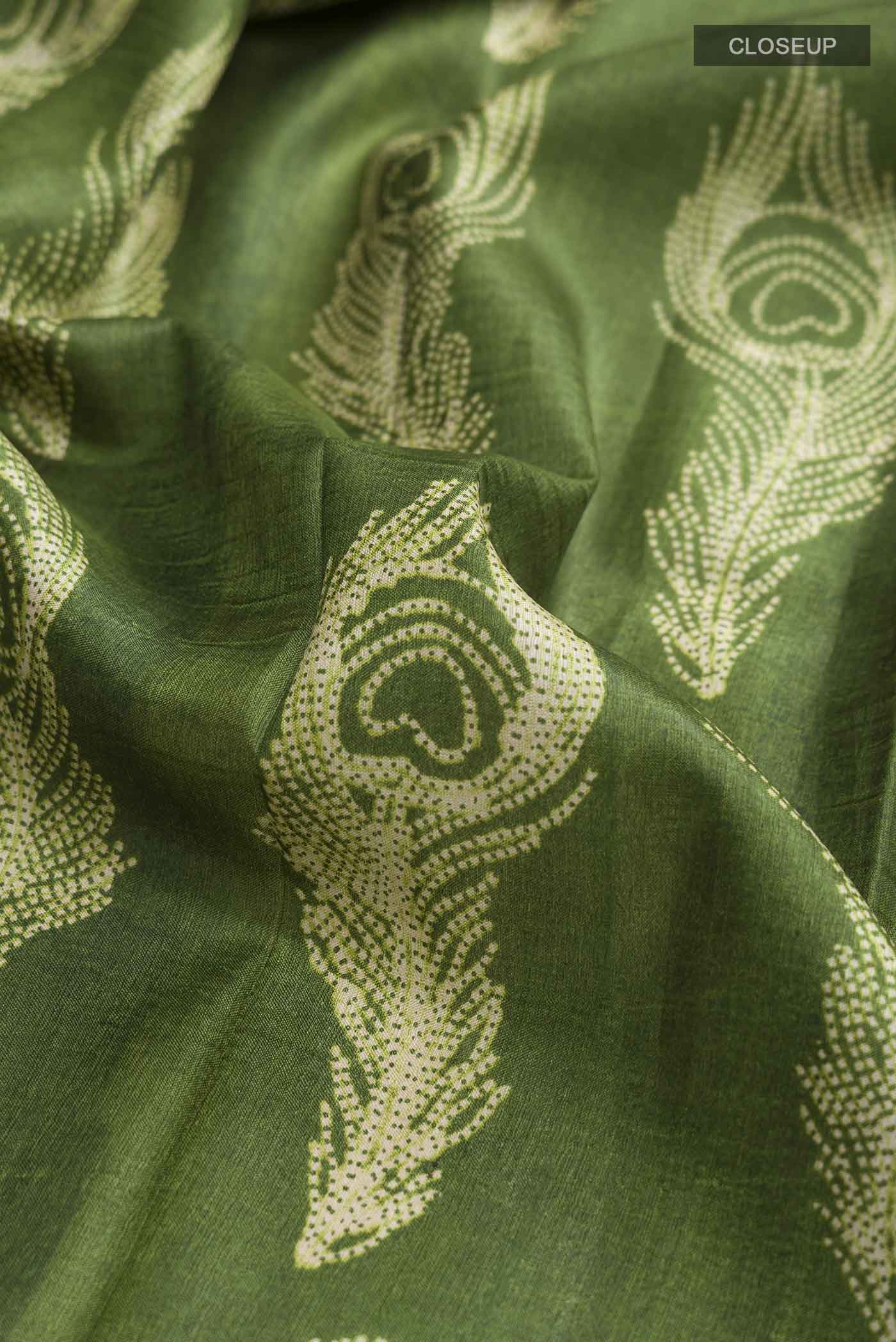 Close up of Green Tussar Silk Saree with Printed design on the body and Printed Border displaying folds