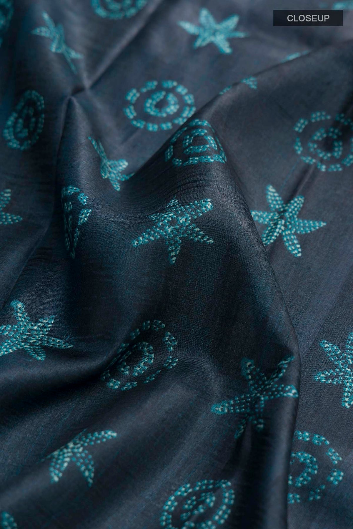 Close up of Blue Bhagalpuri Tussar Silk Saree with Printed design on the body and Printed Border displaying folds