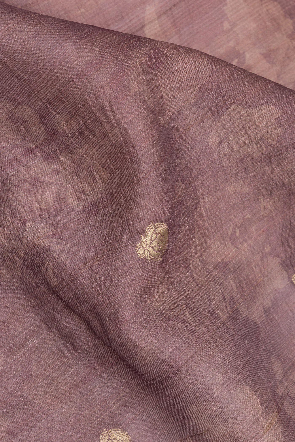 Close up of Pure Silk Mauve Tussar Saree with Zari Butta on the body and Fancy Border.  displaying folds