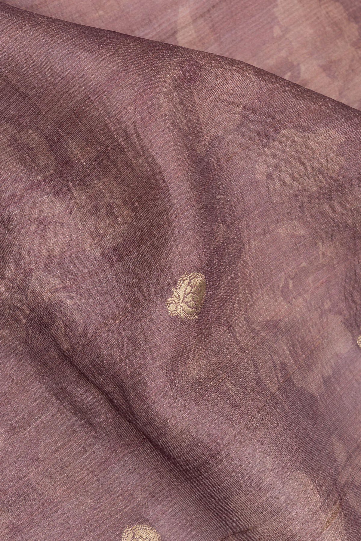 Close up of Pure Silk Mauve Tussar Saree with Zari Butta on the body and Fancy Border.  displaying folds