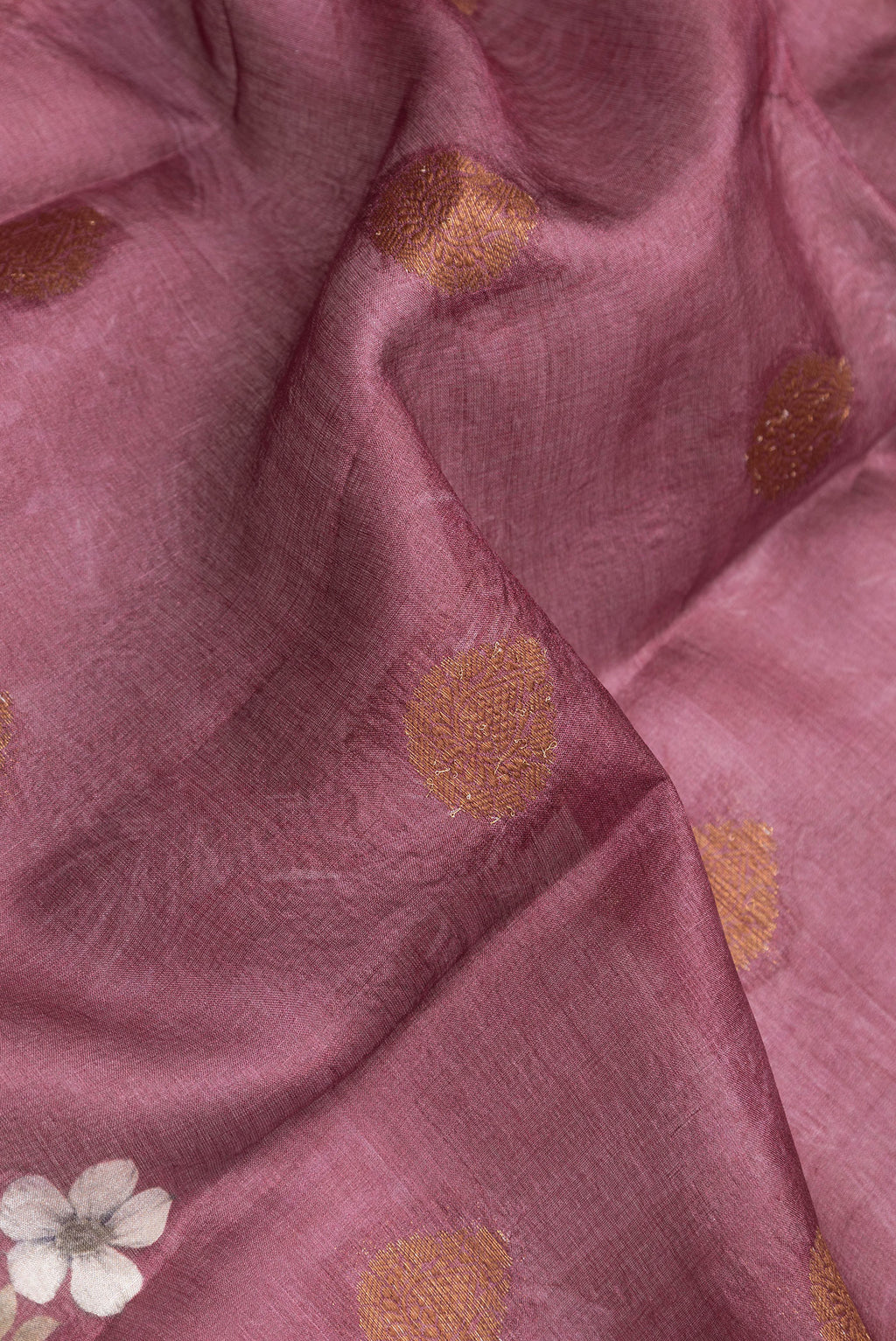 Close up of Mauve Dual Tone Tussar Silk Saree with Printed design on the body and Thread Border.  displaying folds