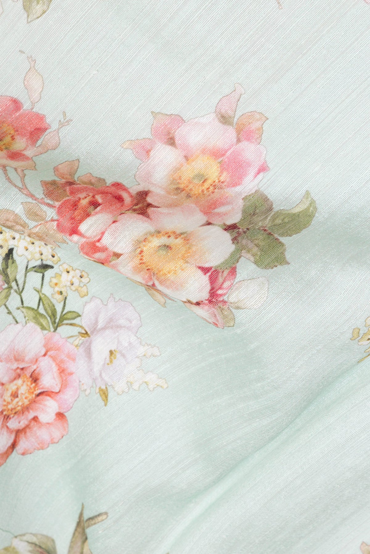 Close up of Sea Green Tussar Silk Saree with Floral Print on the body and Printed Border.  displaying folds