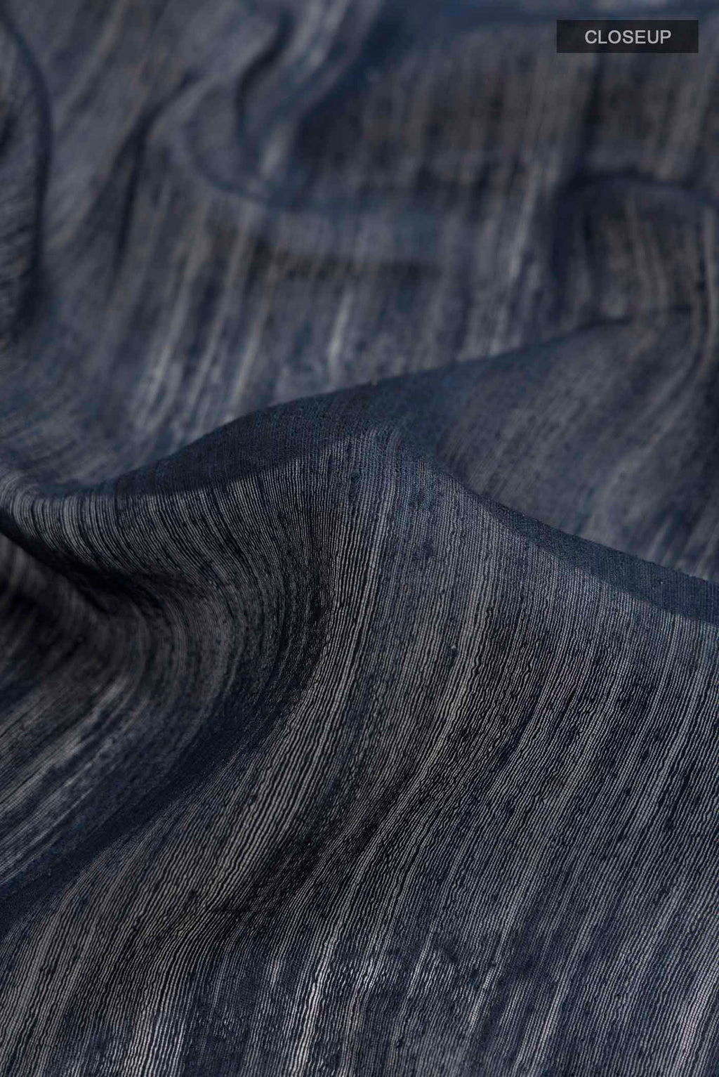 Close up of Blue Tussar Silk Saree with Plain Body and Printed Border displaying folds