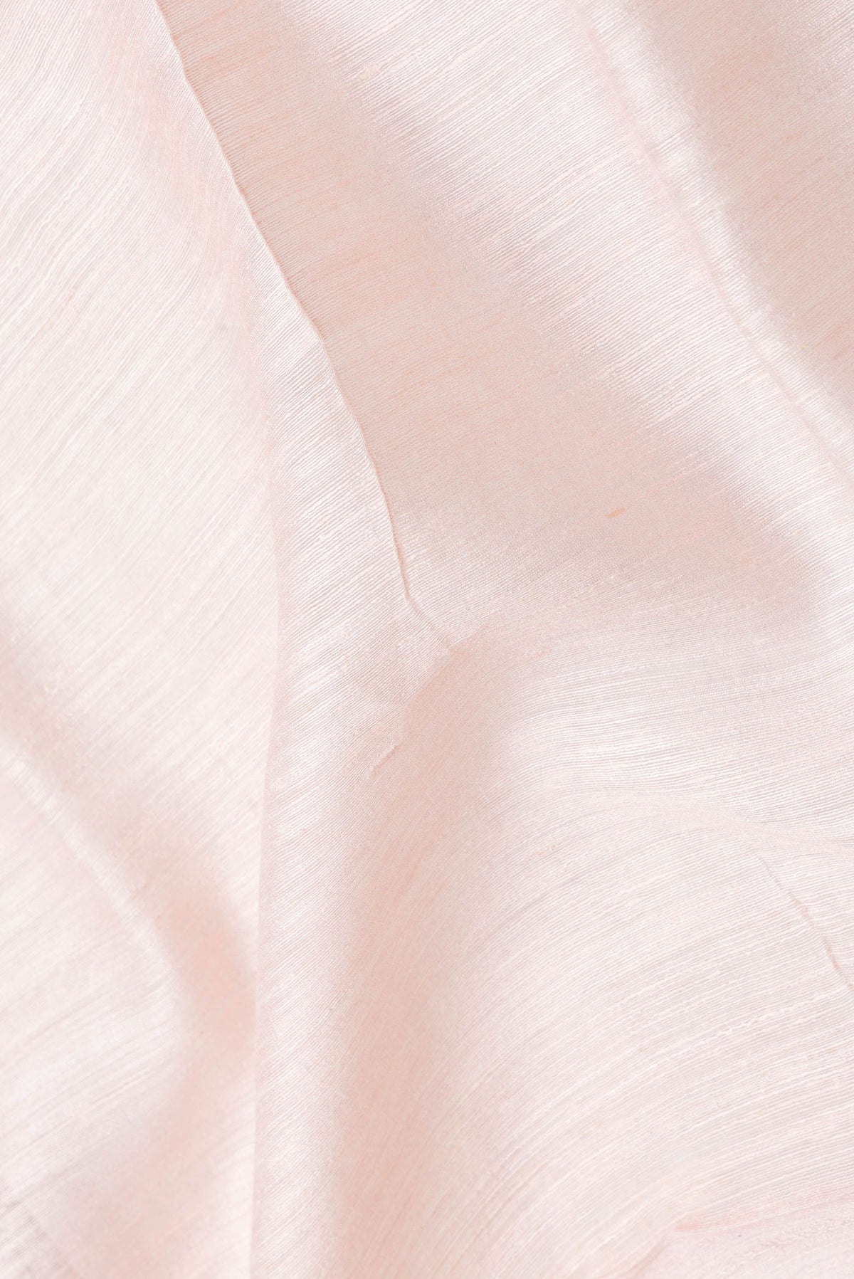 Close up of Rose Gold Dual Tone Tussar Silk Saree with Plain Body and Printed Border.  displaying folds