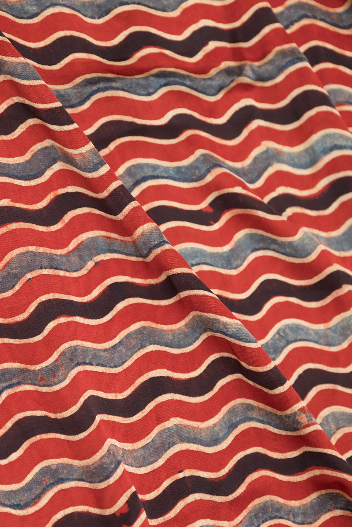 Close up of Maroon Dual Tone Linen Saree with Printed design on the body and Zari Border displaying folds