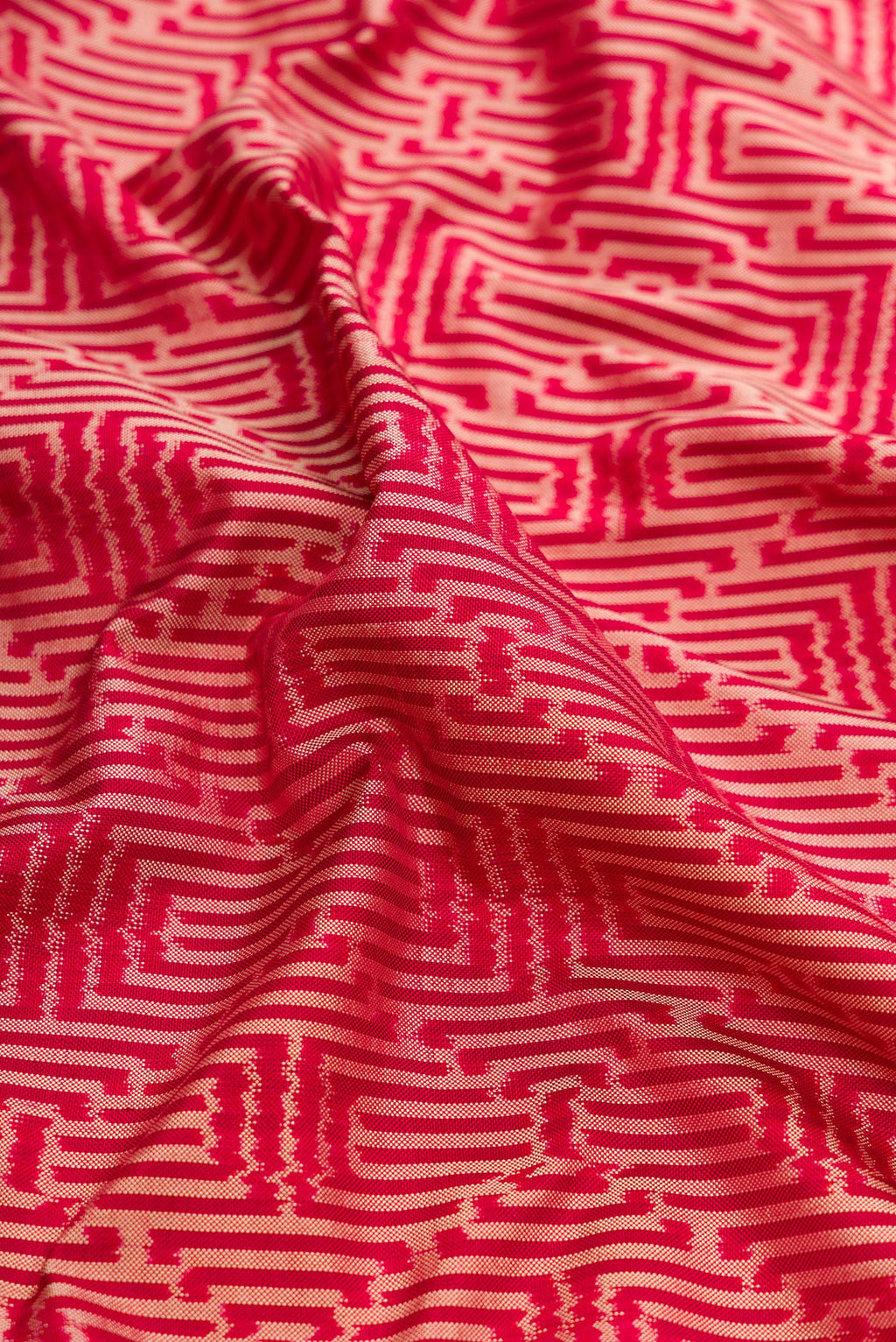 Close up of Maroon Dual Tone Double Ikat Saree with Ikat Print on the body and Thread Border.  displaying folds