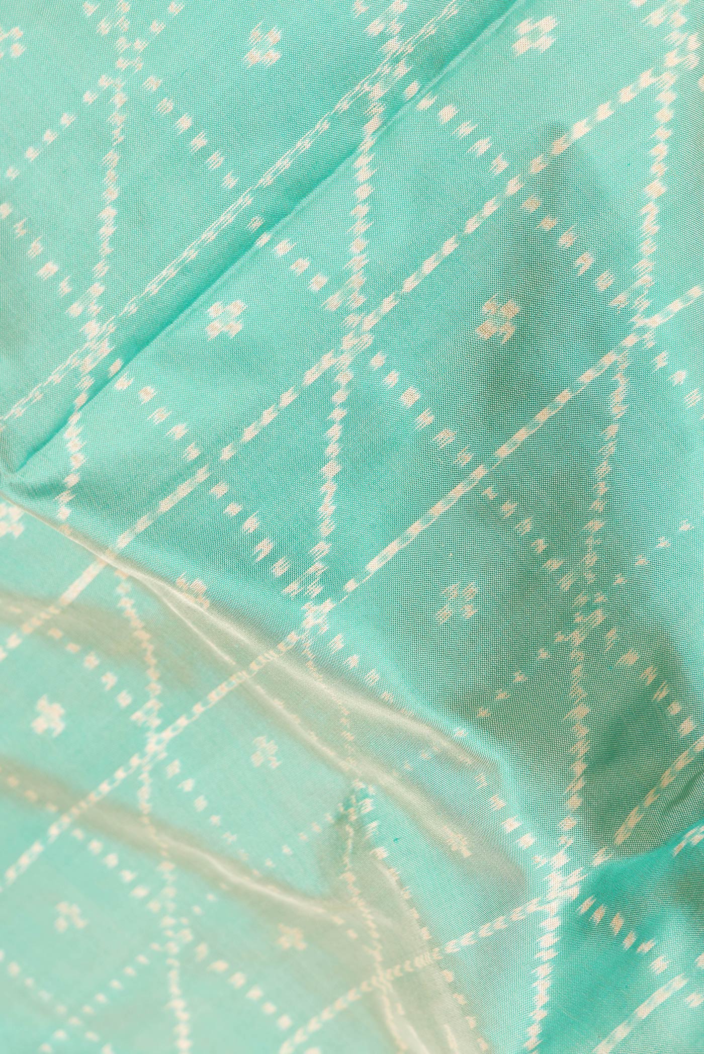Close up of Sea Green Dual Tone Double Ikat Saree with Ikat Print on the body and Ikat Border.  displaying folds