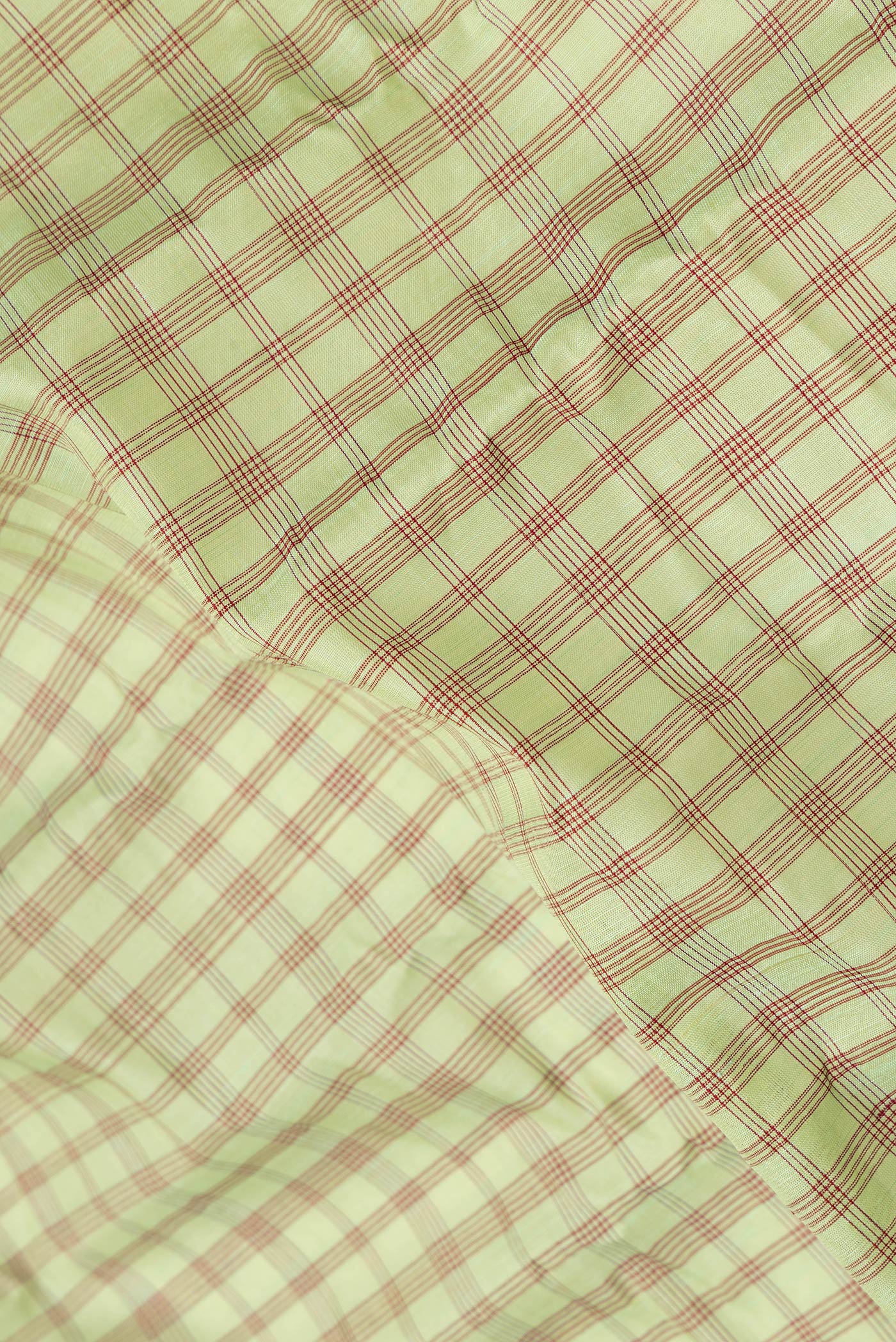 Close up of Pista Green Dual Tone Gadwal Silk Saree with Checked design on the body and Plain Border.  displaying folds