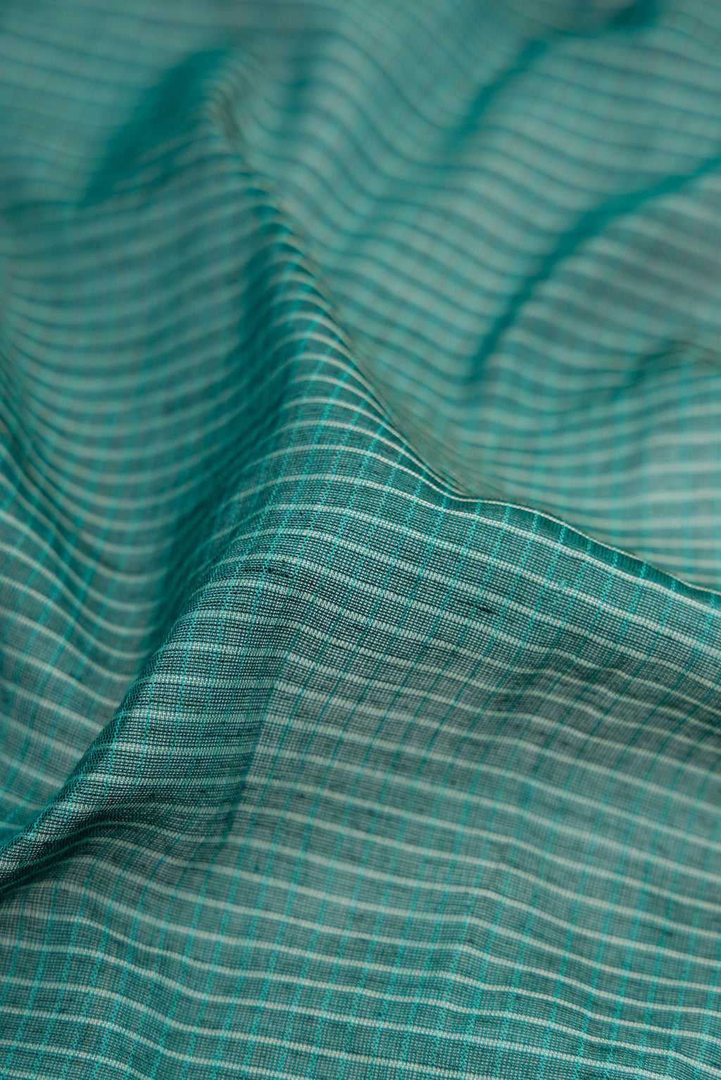 Close up of Green Gadwal cotton Saree with Checked design on the body and Silk Border.  displaying folds