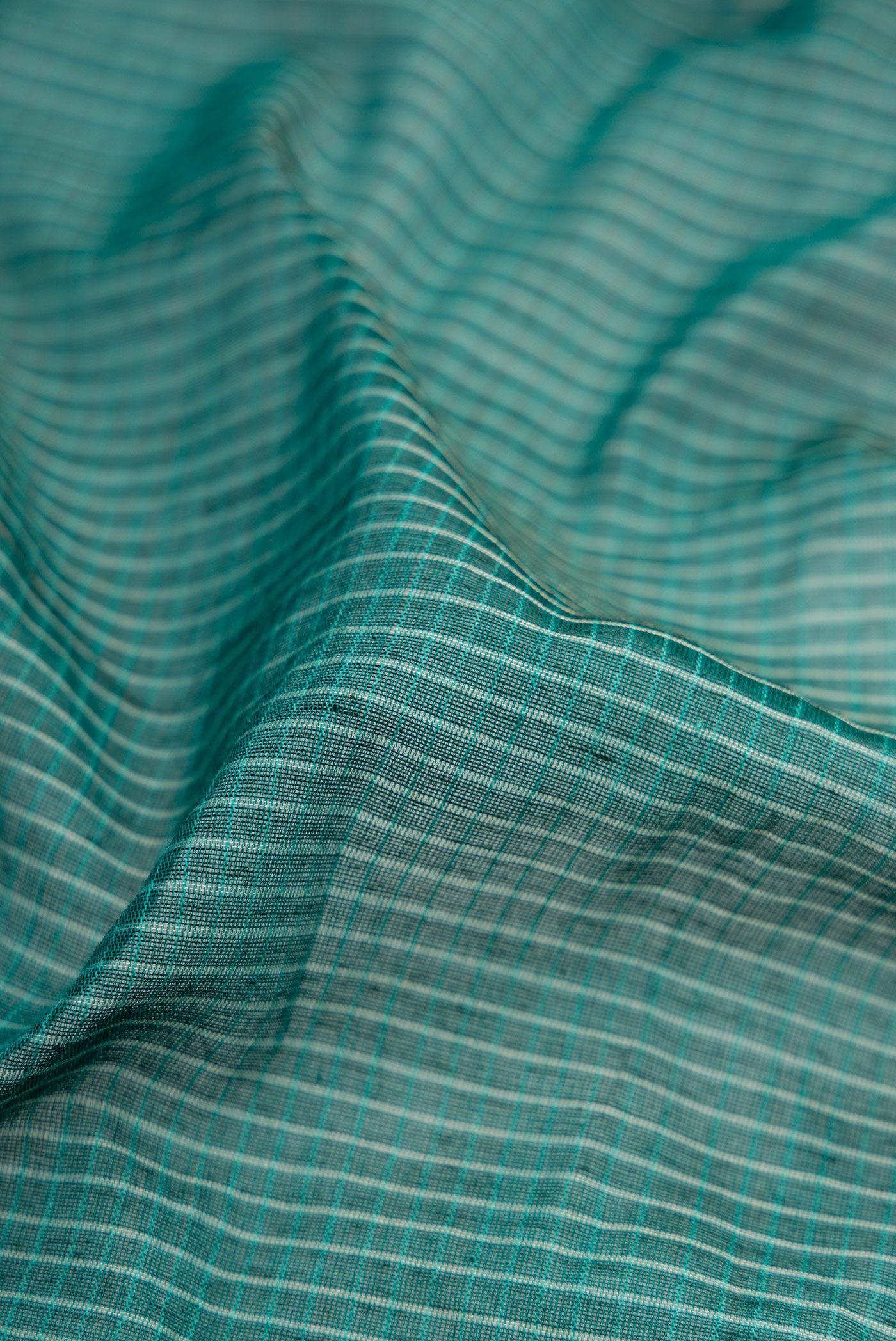 Close up of Green Gadwal cotton Saree with Checked design on the body and Silk Border.  displaying folds