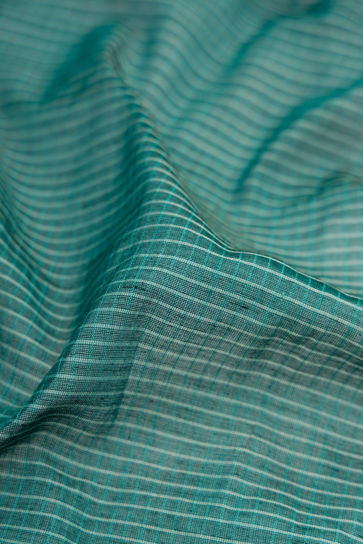 Close up of Green Gadwal cotton Saree with Checked design on the body and Silk Border.  displaying folds