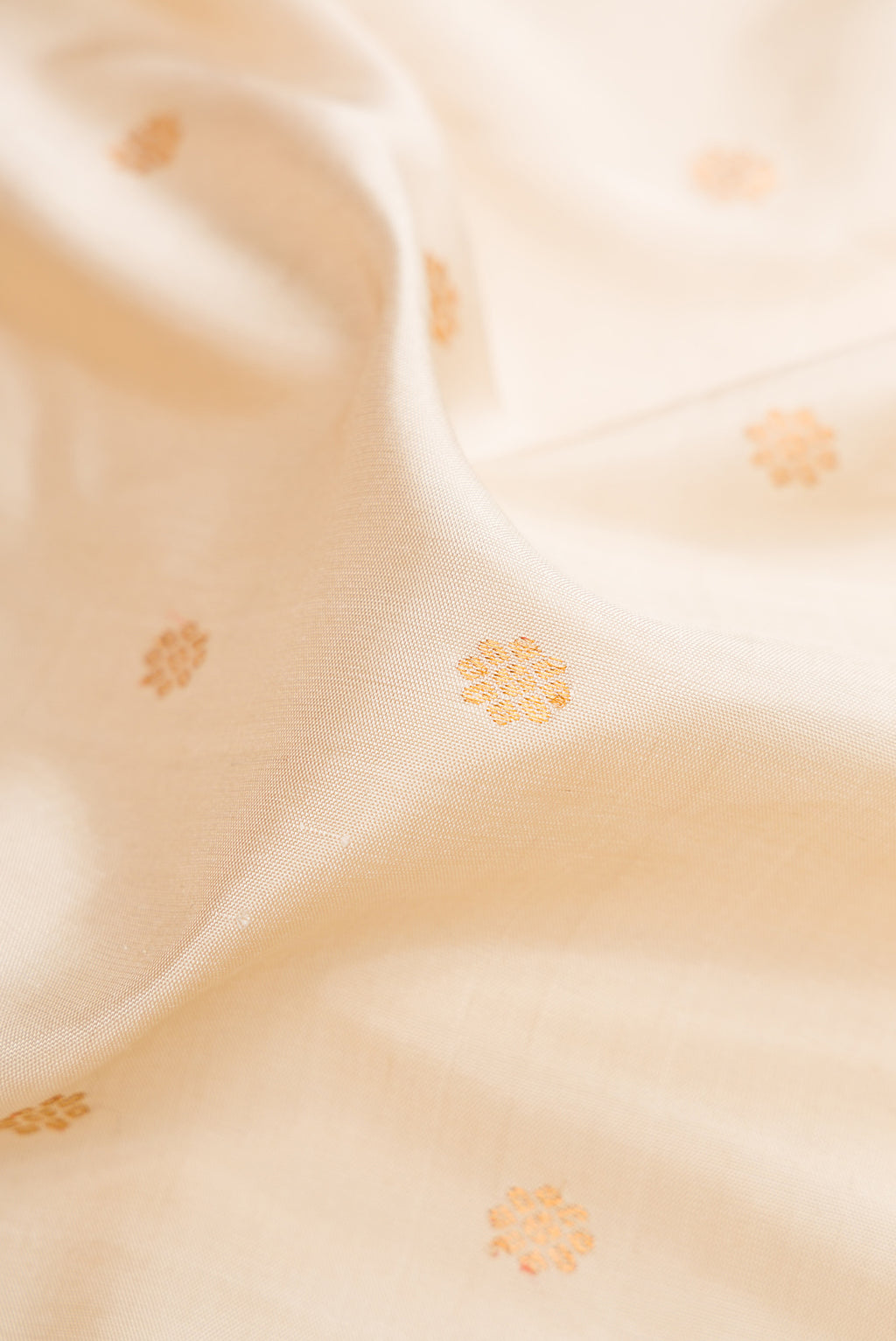 Close up of Off White Gadwal Silk Saree with Zari Butta on the body and Zari Border.  displaying folds