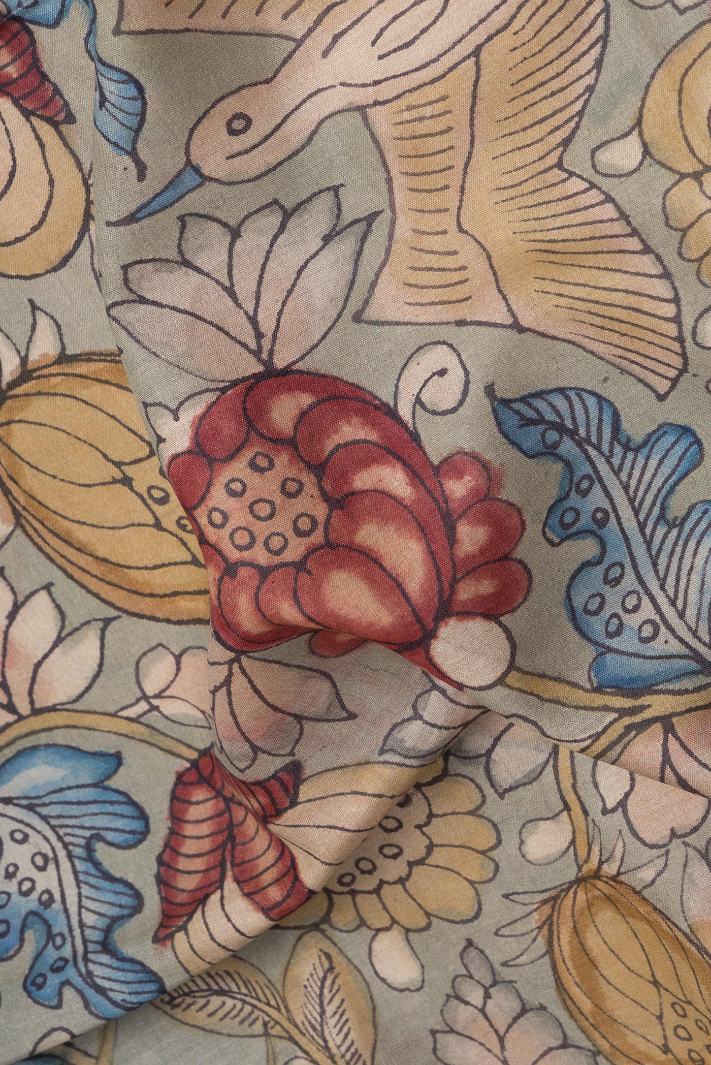 Close up of Green Tussar Silk Saree with kalamkari Print on the body and Zari Border.  displaying folds