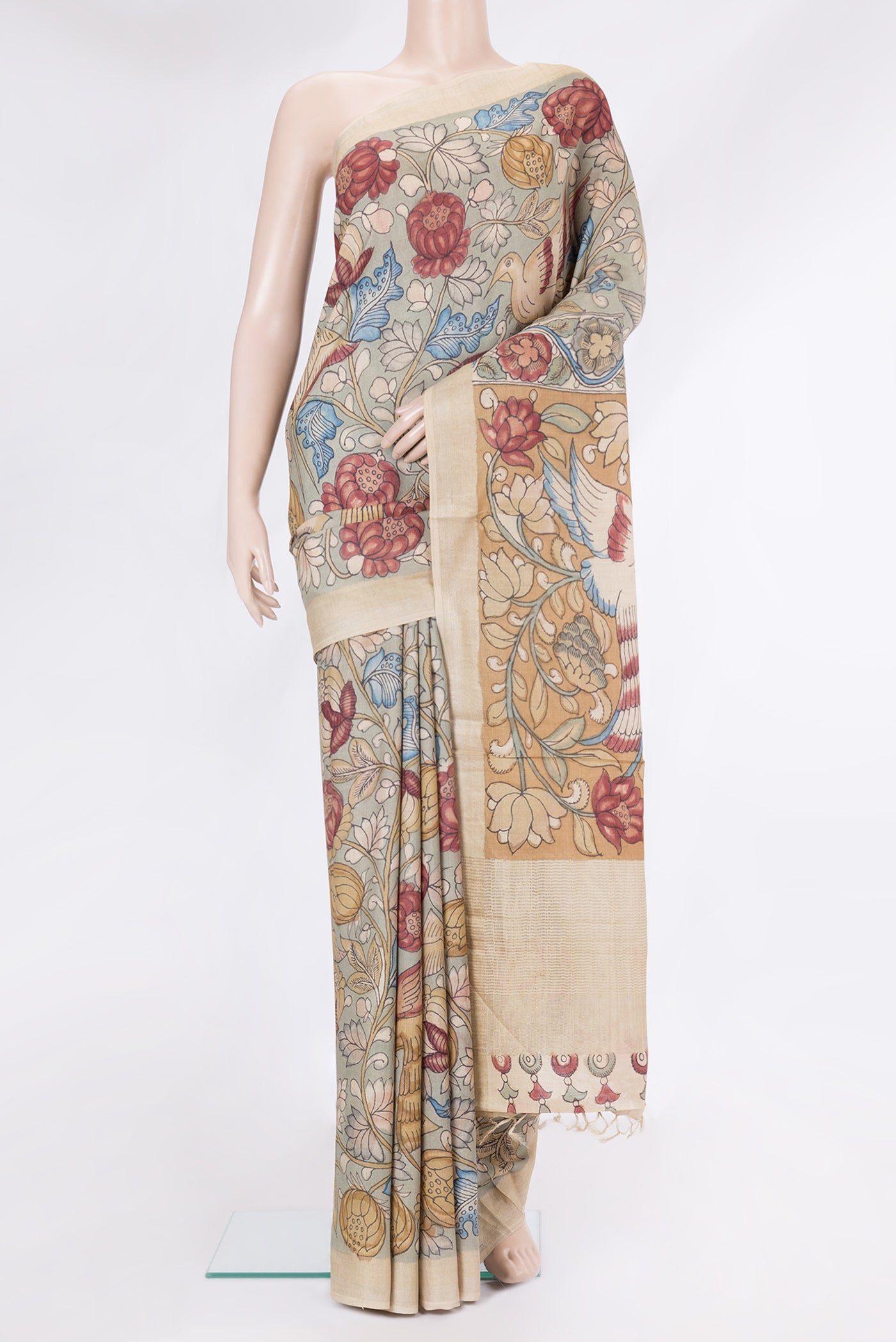 Green Tussar Silk Saree with kalamkari Print on the body and Zari Border.  displayed on a mannequin