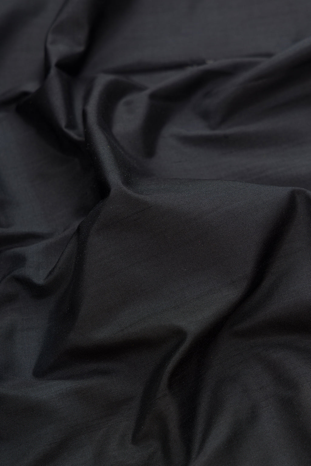 Close up of Black Dual Tone Double Ikat Saree with Plain Body and Temple Border.  displaying folds