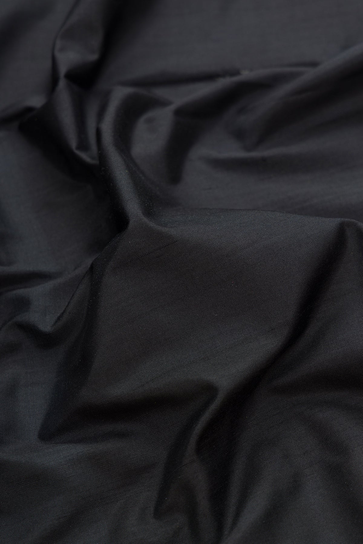 Close up of Black Dual Tone Double Ikat Saree with Plain Body and Temple Border.  displaying folds
