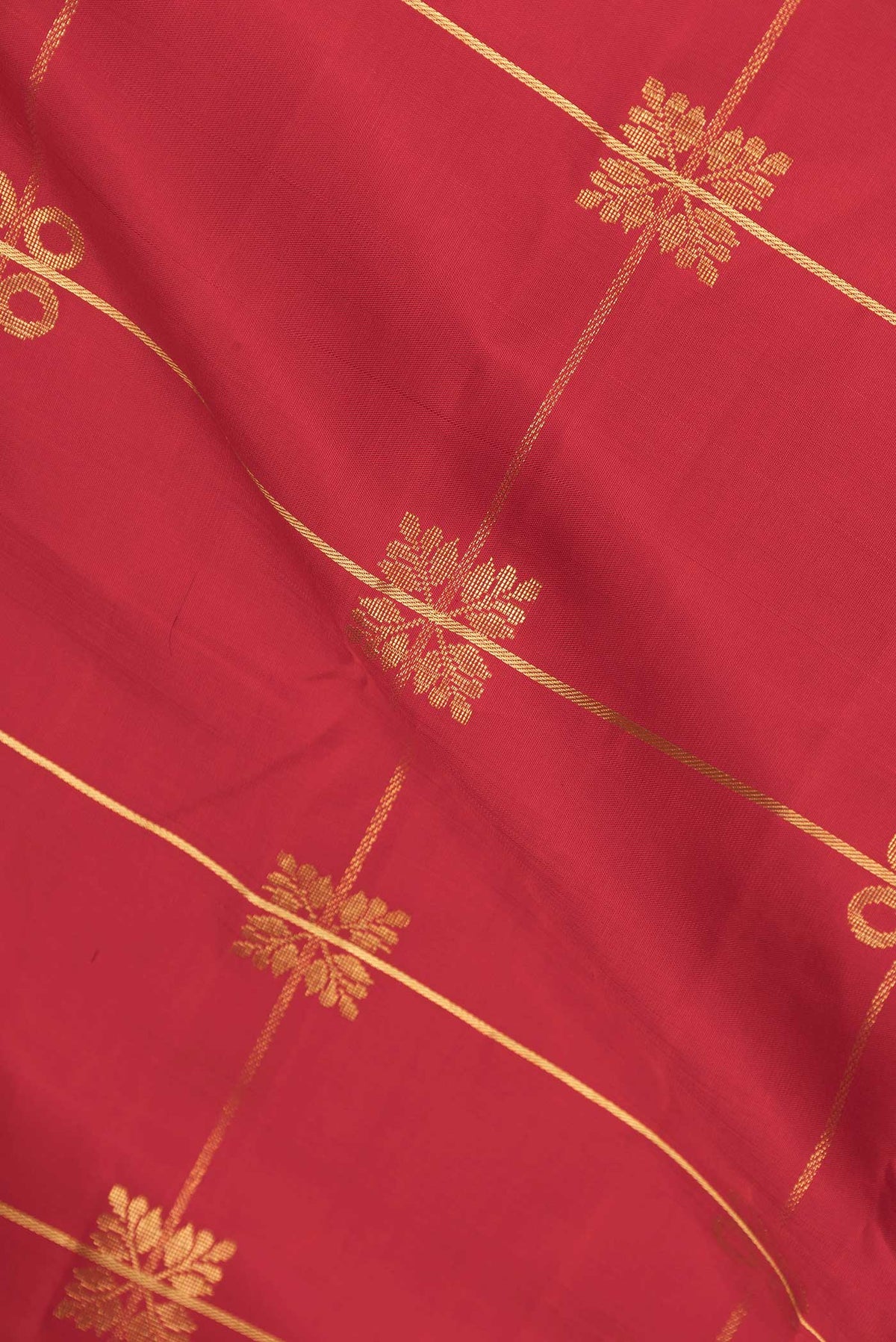 Close up of Red Dual Tone Kanchipuram Silk Saree with Checked design on the body and Zari Border displaying folds