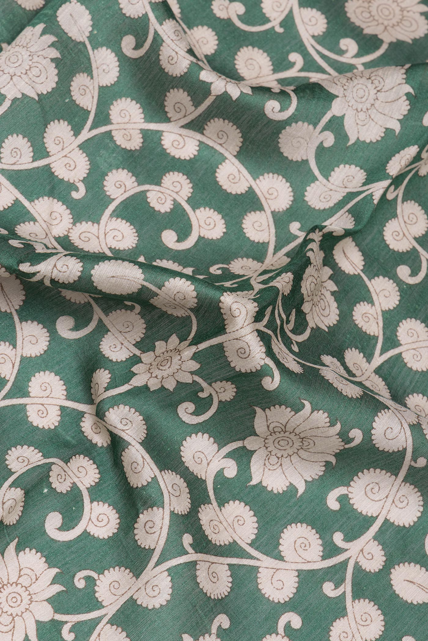 Close up of Green Tussar Silk Saree with Printed design on the body and Zari Border.  displaying folds