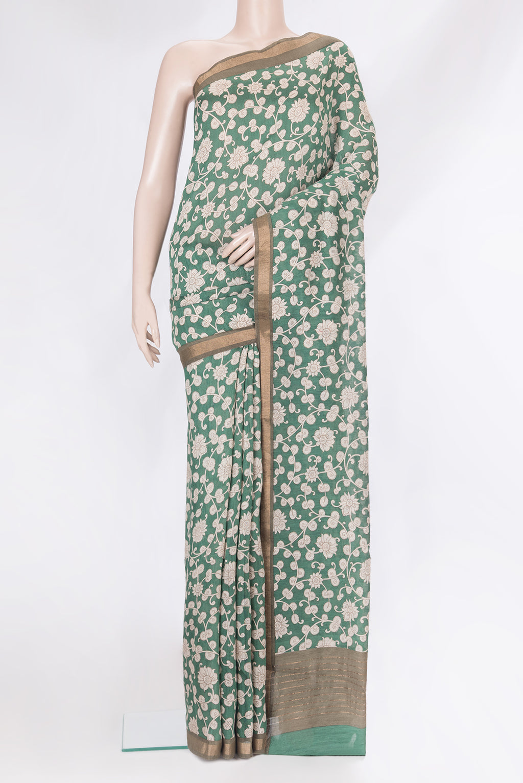 Green Tussar Silk Saree with Printed design on the body and Zari Border.  displayed on a mannequin