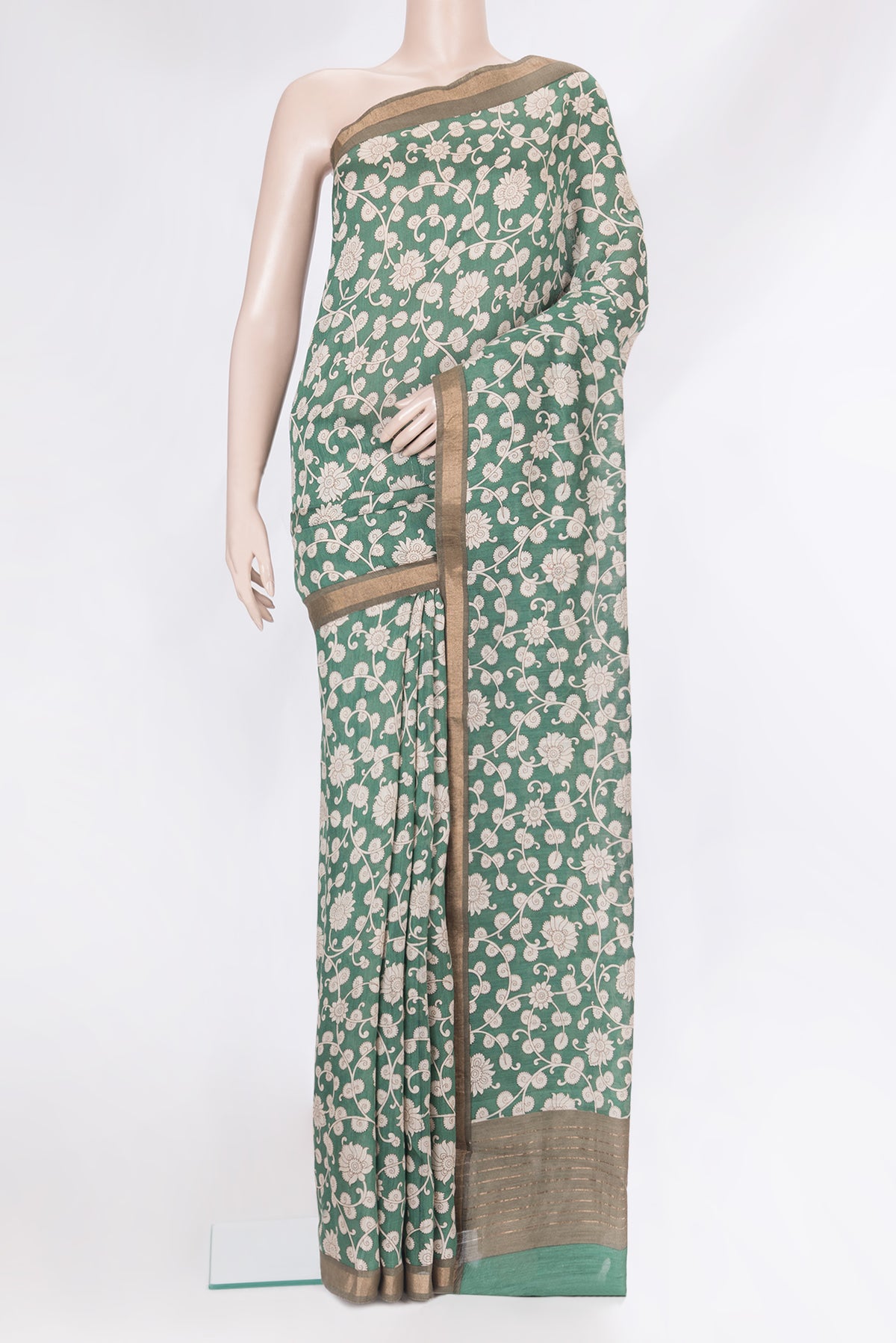 Green Tussar Silk Saree with Printed design on the body and Zari Border.  displayed on a mannequin