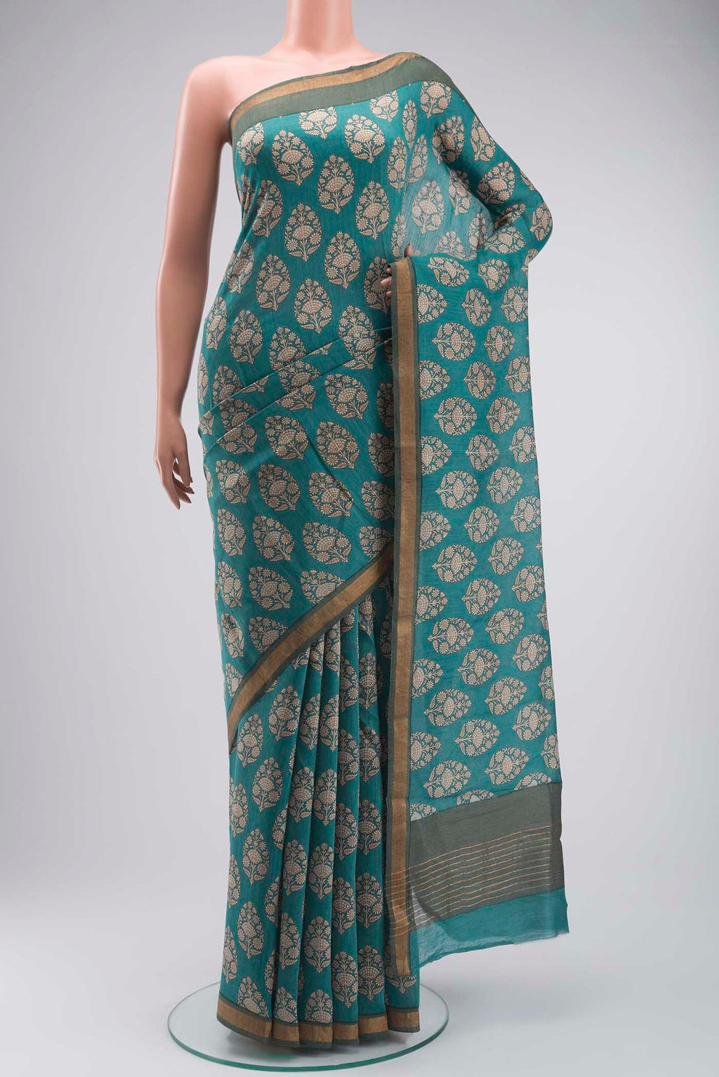 Green Tussar Silk Saree with Printed design on the body and Zari Border displayed on a mannequin