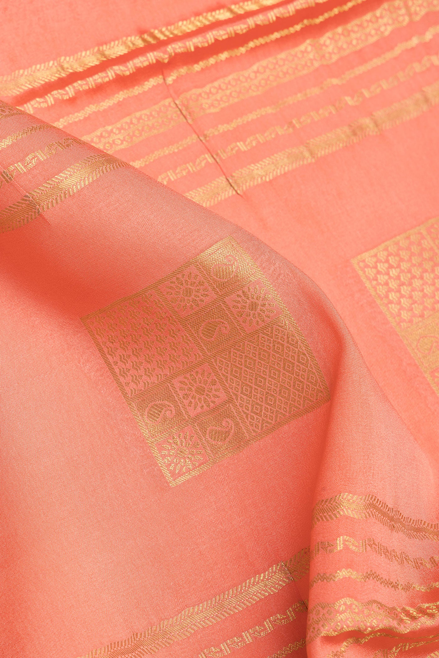 Close up of Peach Mysore Silk Saree with Checked design on the body and Zari Border.  displaying folds