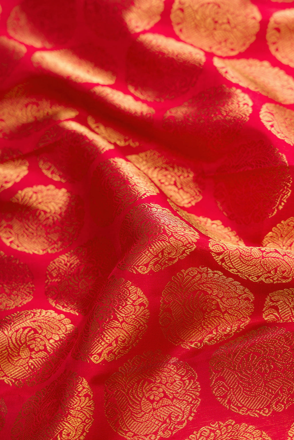 Close up of Pure Silk Pure Zari Red Dual Tone Kanjivaram Saree with Zari Brocade on the body and Zari Border.  displaying folds