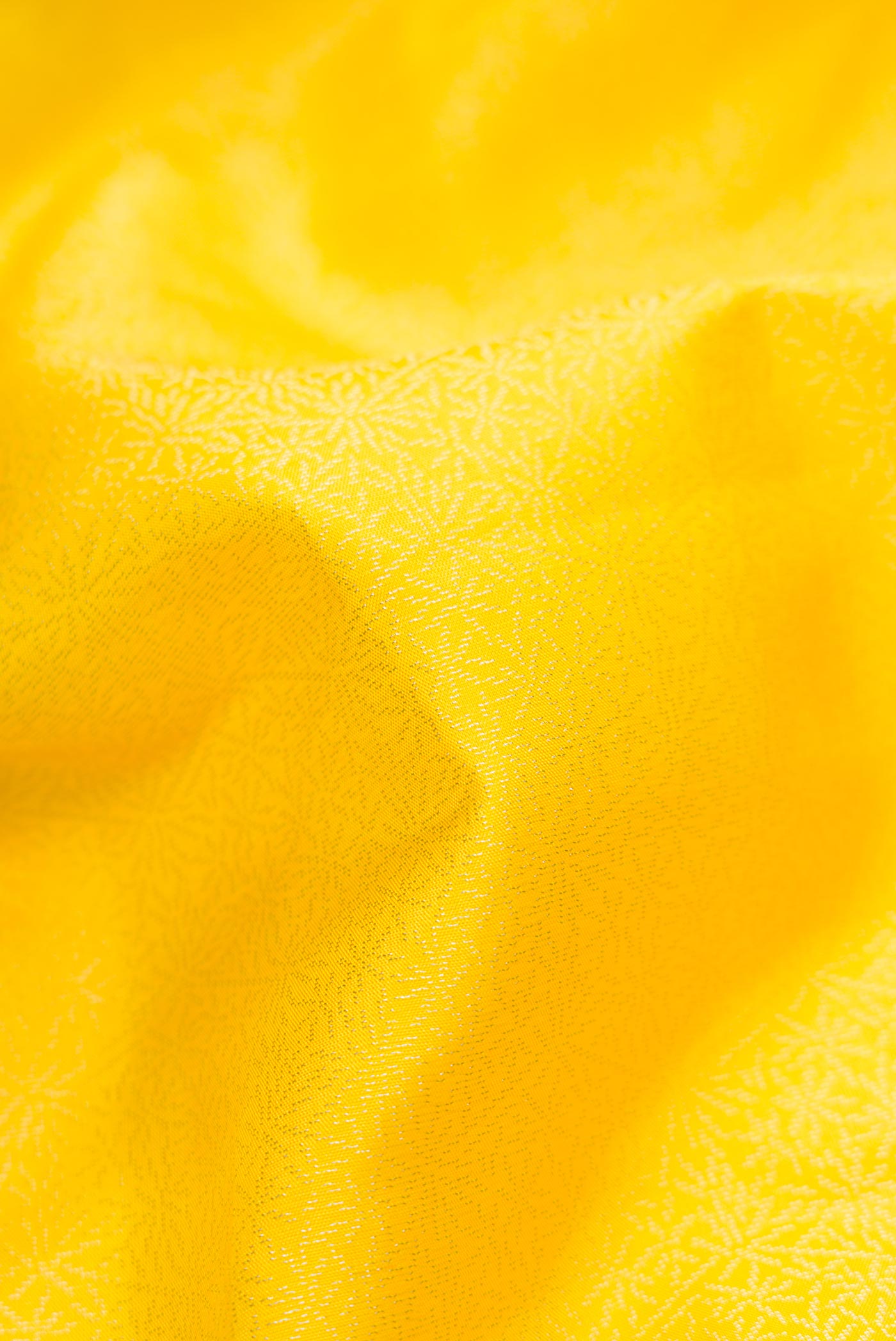Close up of Yellow Dual Tone Soft Silk Saree with Zari Brocade on the body and Zari Border.  displaying folds