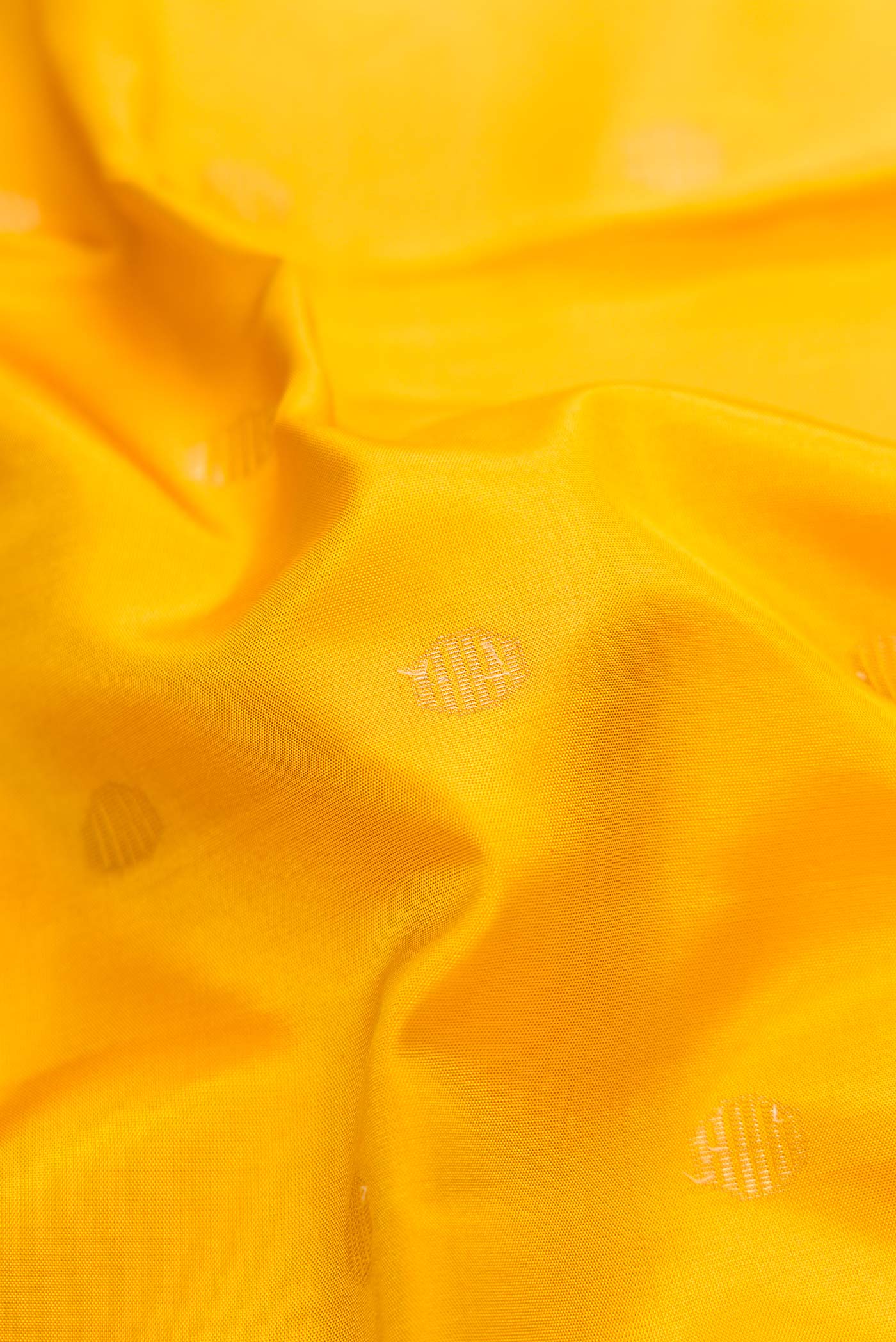 Close up of Mustard Dual Tone Soft Silk Saree with Zari Butta on the body and Zari Border.  displaying folds