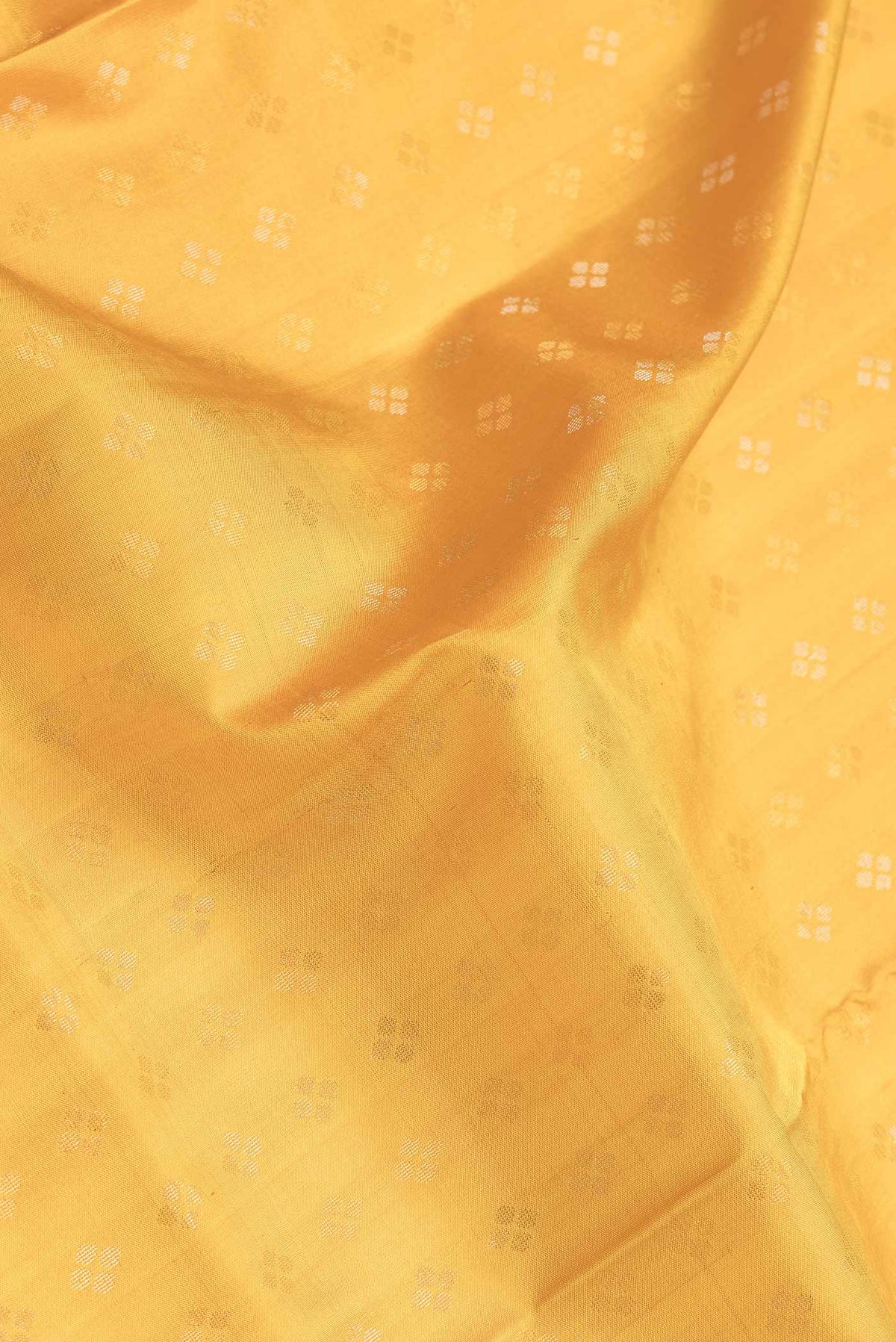 Close up of Mustard Dual Tone Soft Silk Saree with Zari Butta on the body and Zari Border.  displaying folds