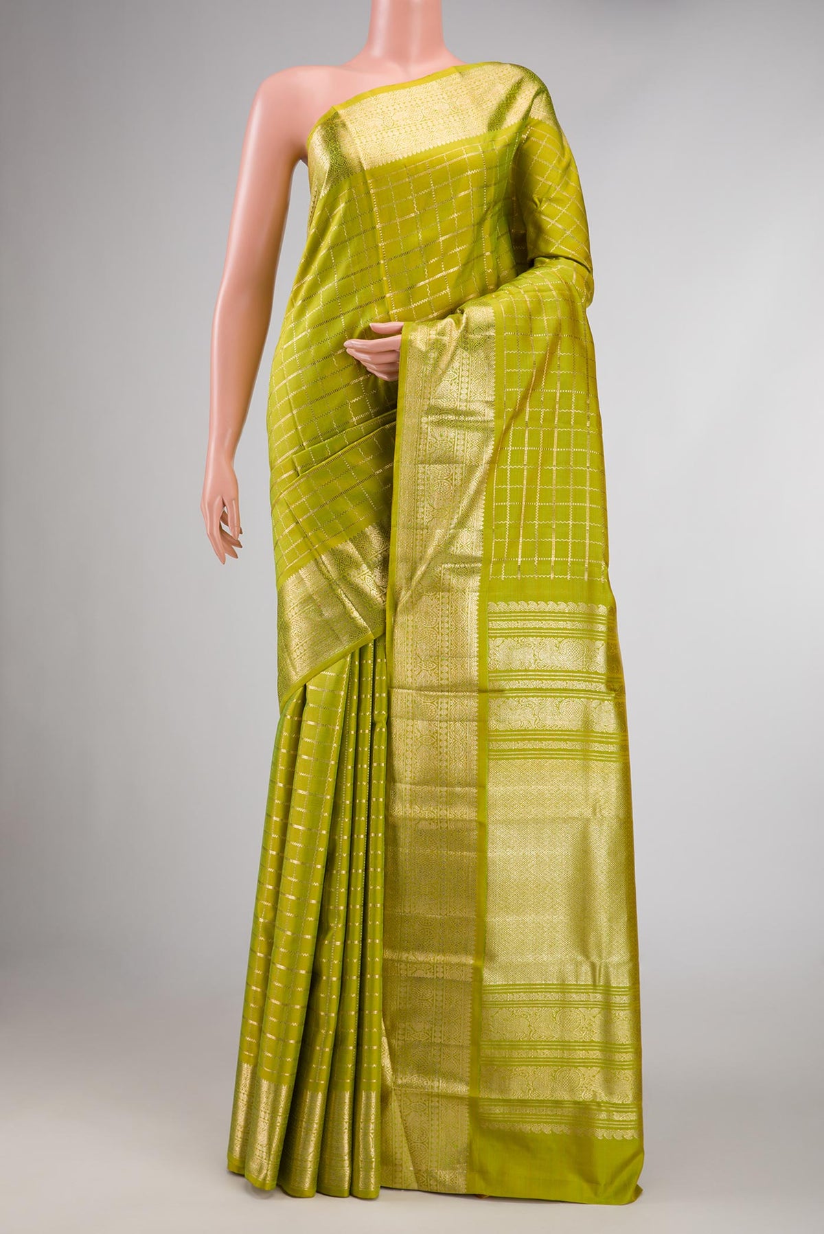 Parrot Green Kanchipuram Silk Saree with Checked design on the body and Zari Border displayed on a mannequin