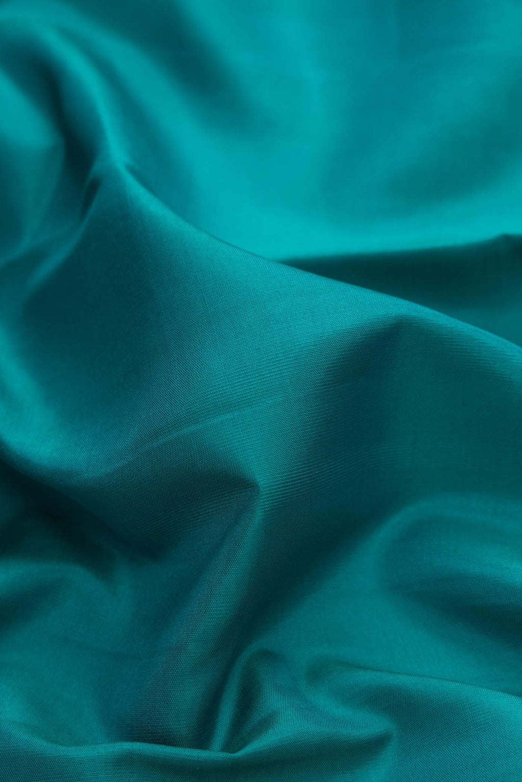 Close up of Pure Silk Pure Zari Green Dual Tone Kanchipuram Saree with Plain Body and Zari Border displaying folds